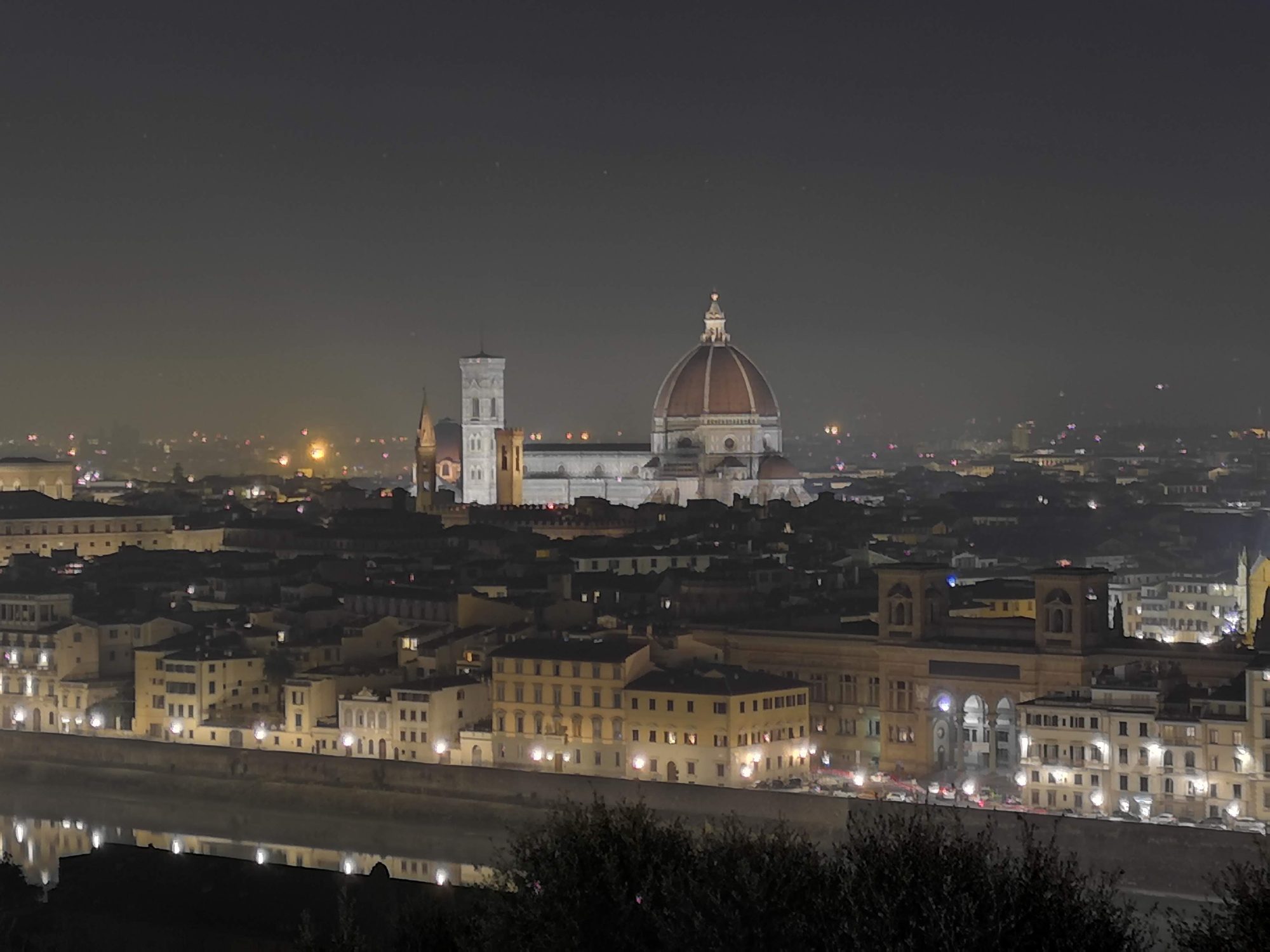Vista nocturna de Florencia con la catedral de Santa María del Fiore iluminada.