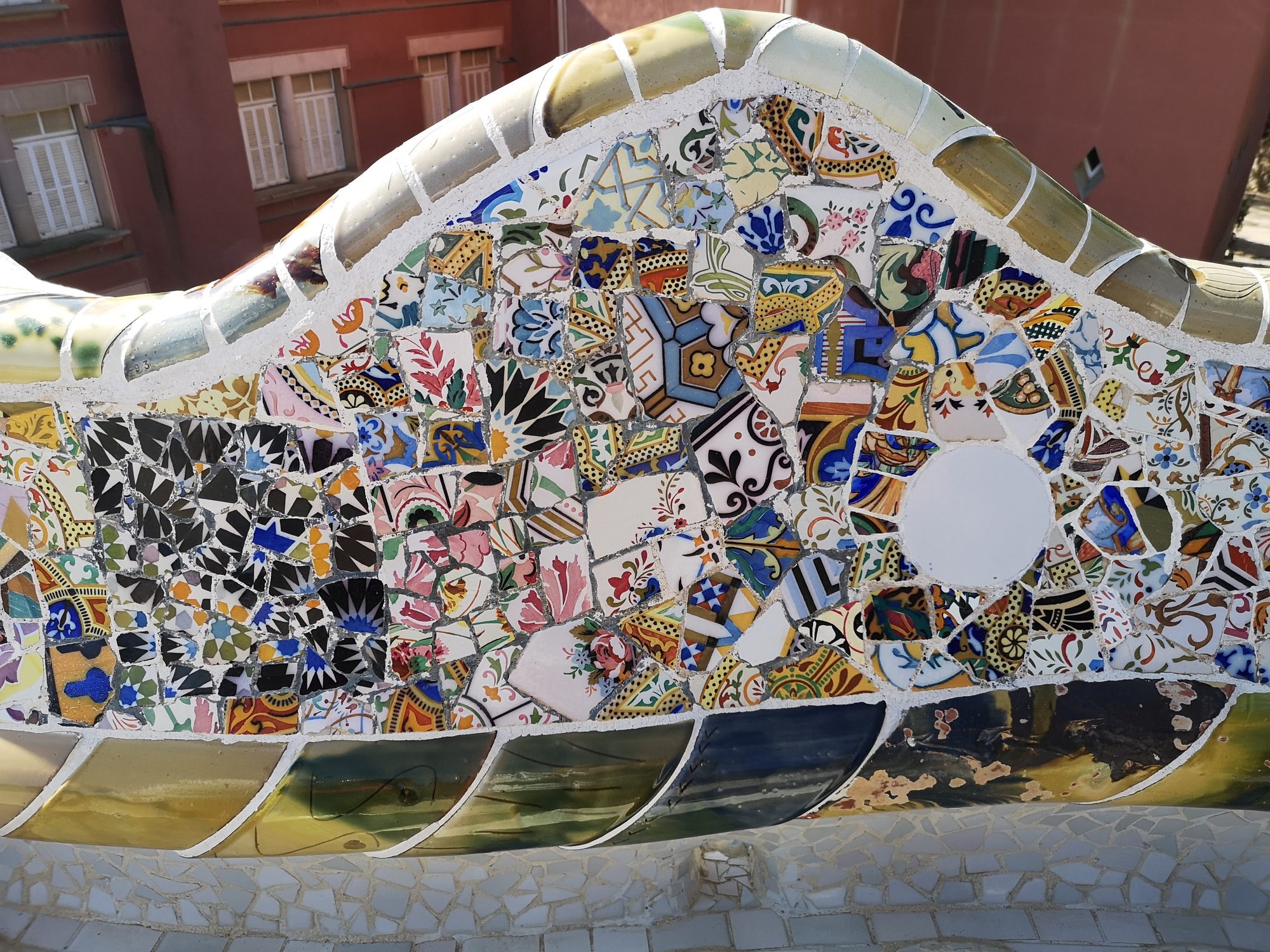 Mosaico de cerámica trencadís en el banco ondulado del Park Güell en Barcelona.