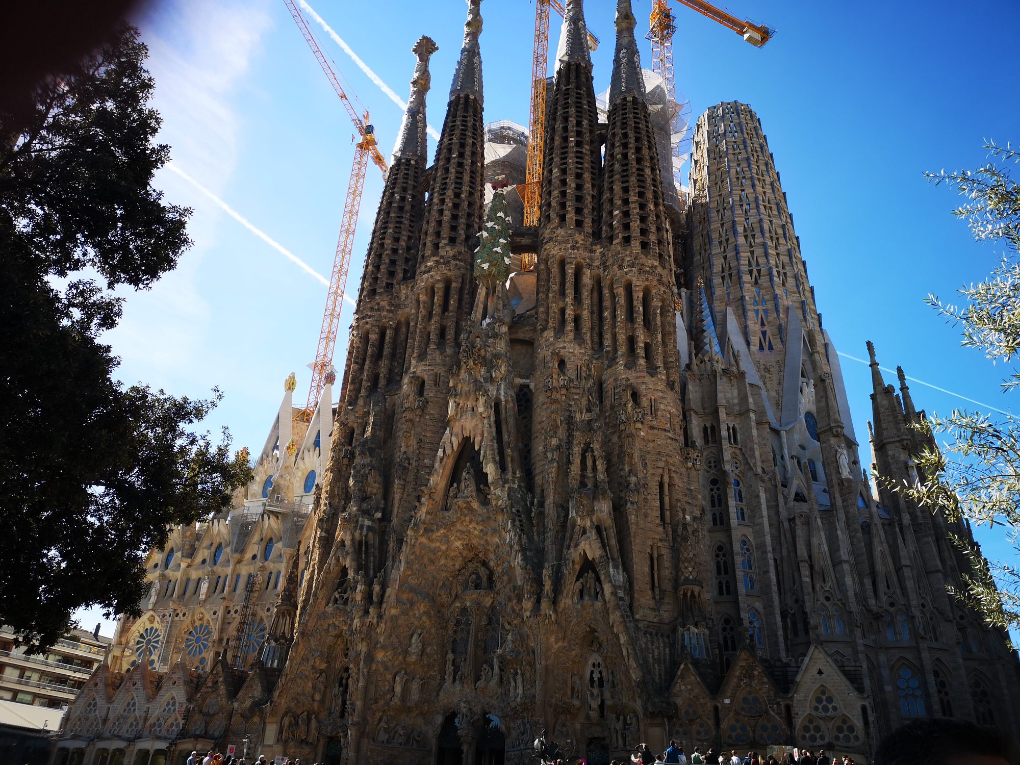 Fachada del Nacimiento y torres de la Sagrada Familia bajo un cielo azul