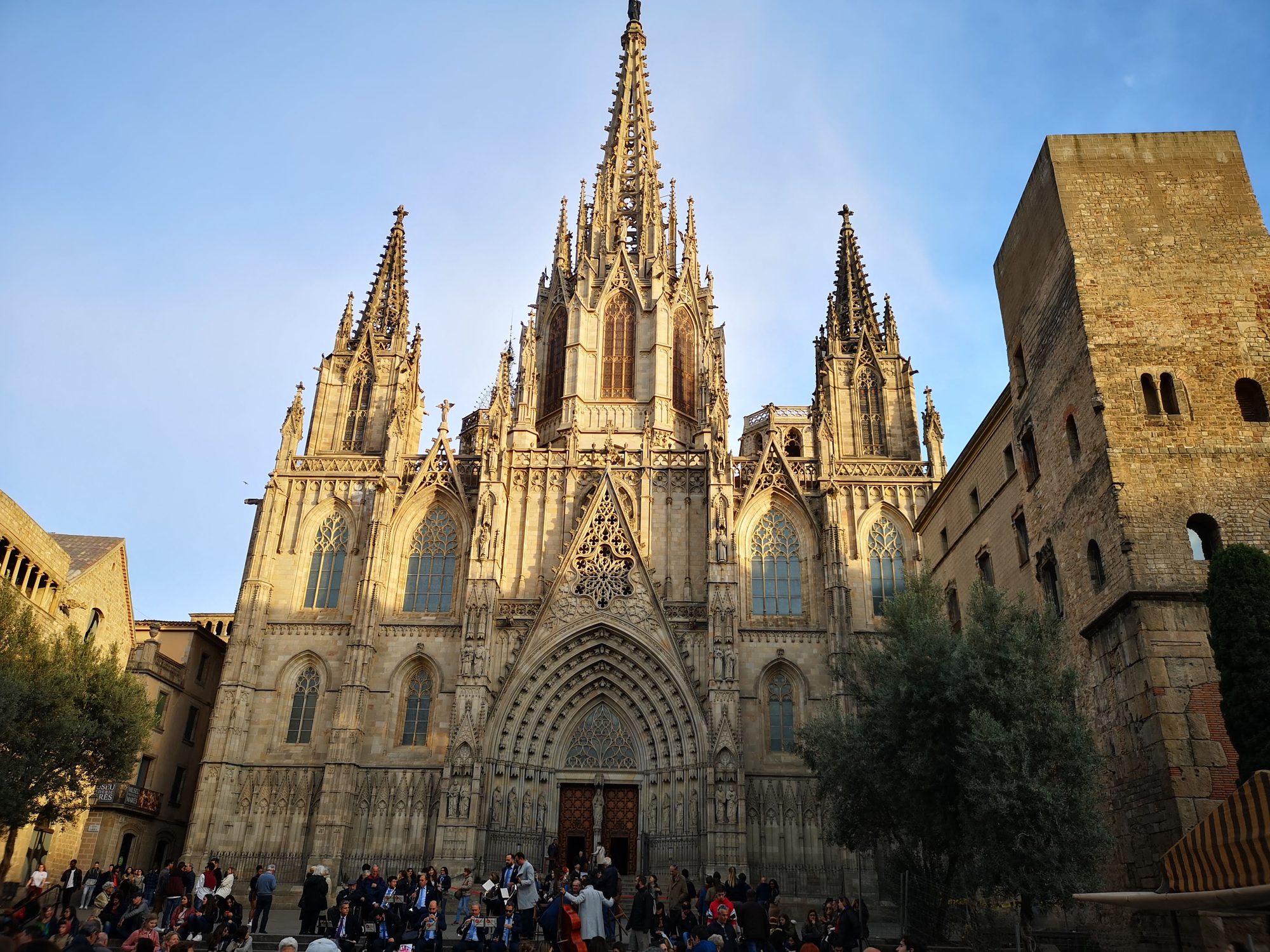 Fachada gótica y agujas de la Catedral de Barcelona iluminadas por el sol.