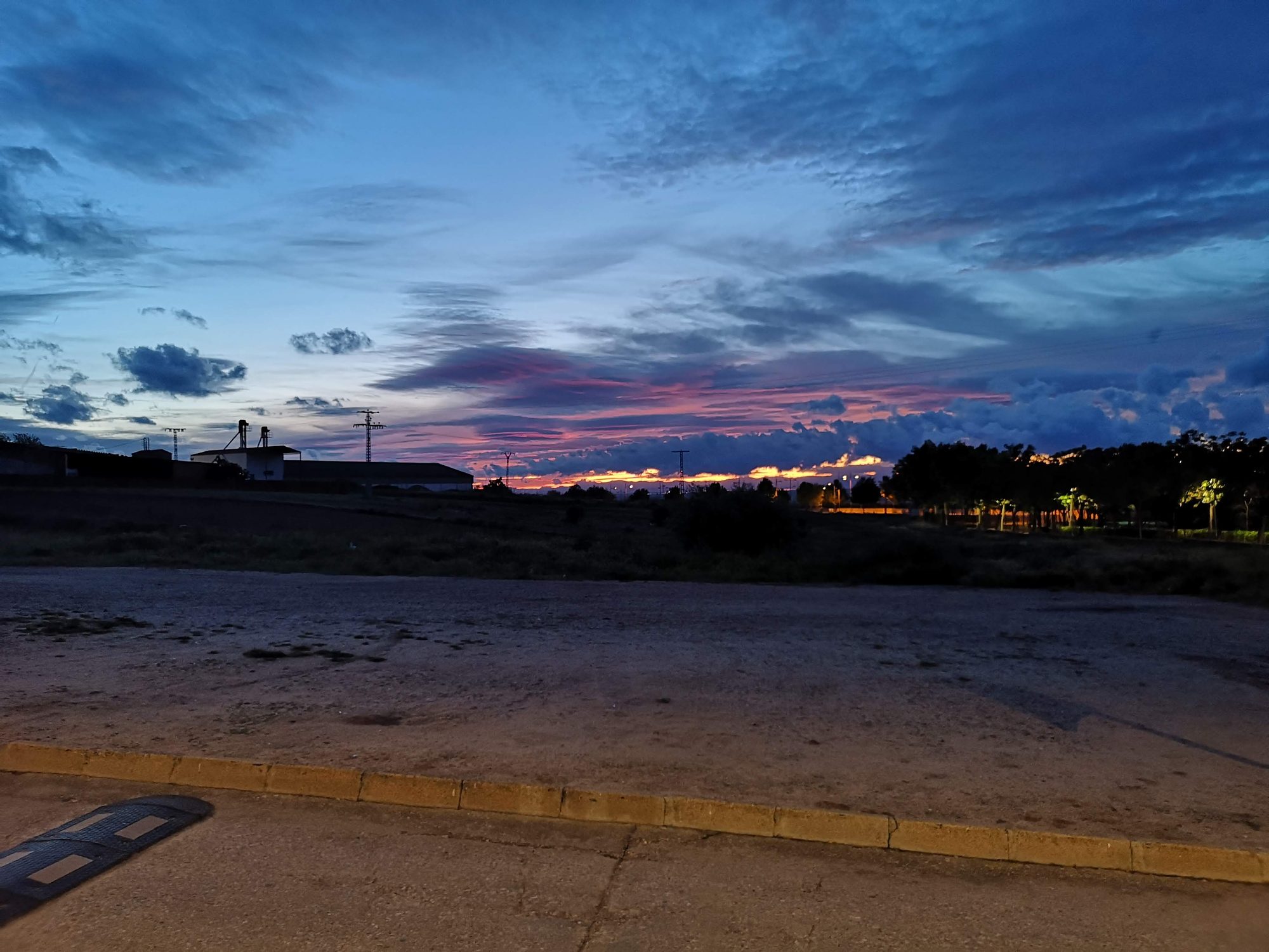 Atardecer con nubes rosadas y cielo azul oscuro sobre el horizonte en Bargas.