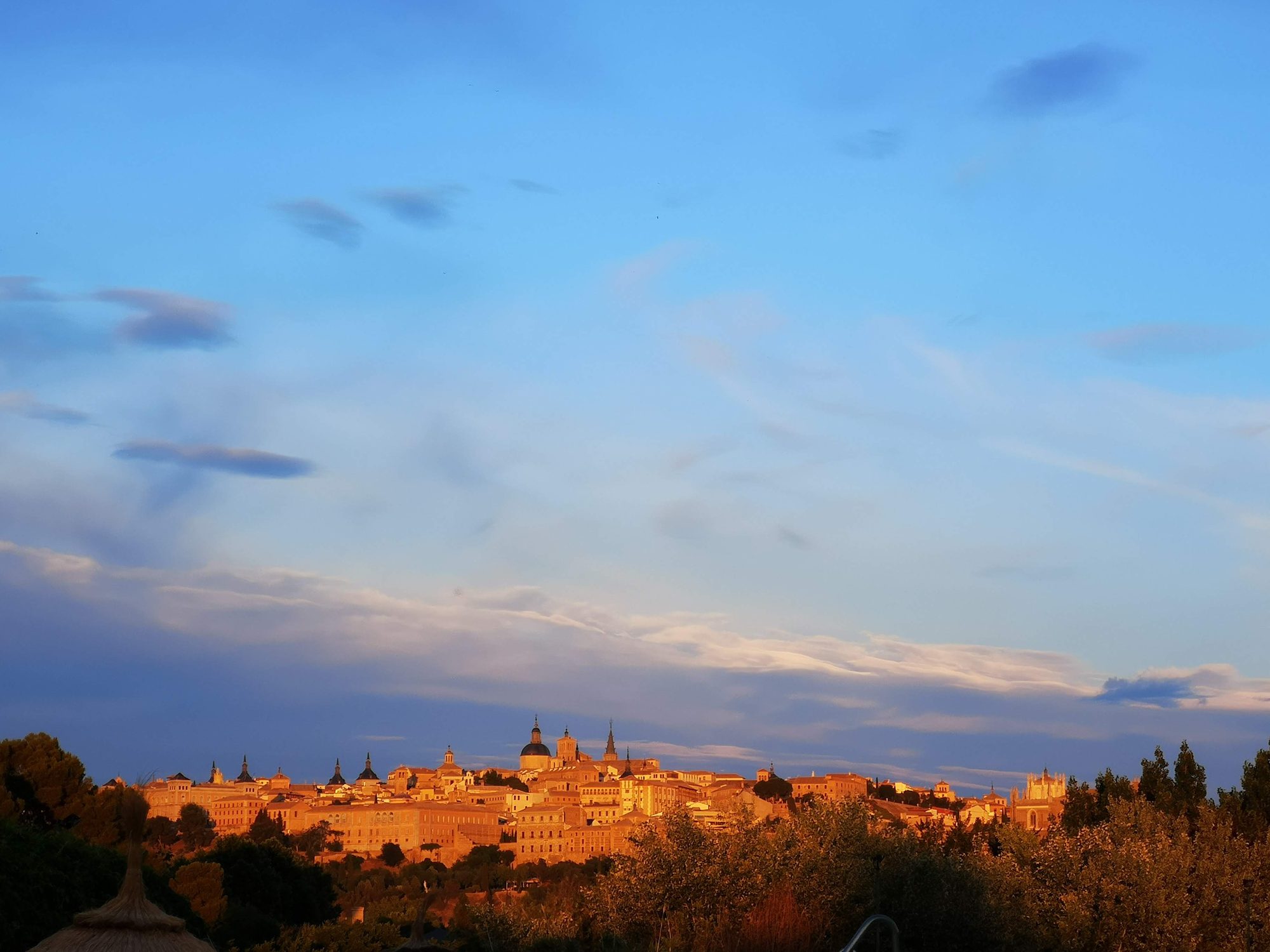 Panorámica del casco histórico de Toledo iluminado por la luz dorada del atardecer.