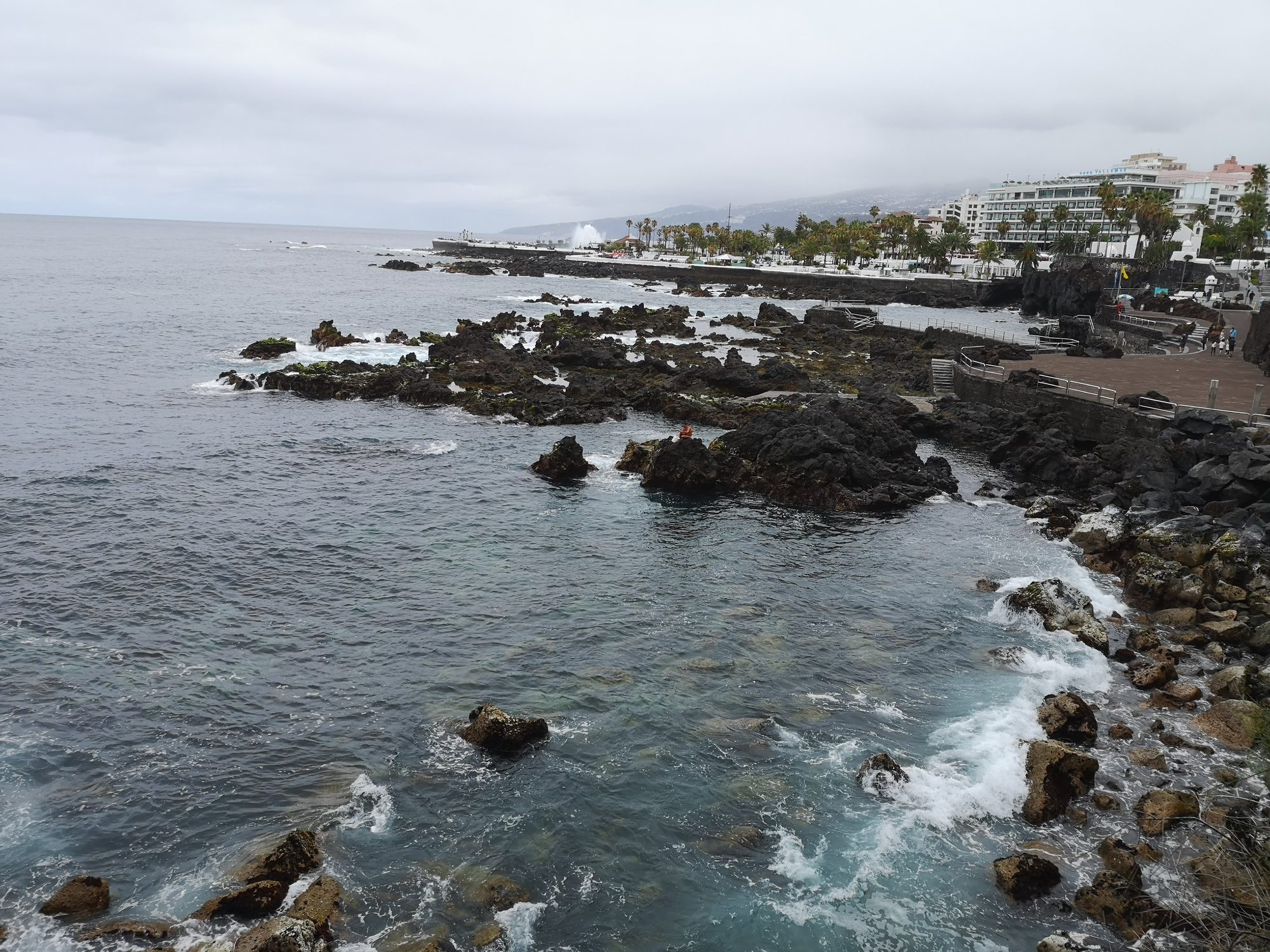 Costa rocosa volcánica con olas del mar rompiendo en Puerto de la Cruz.