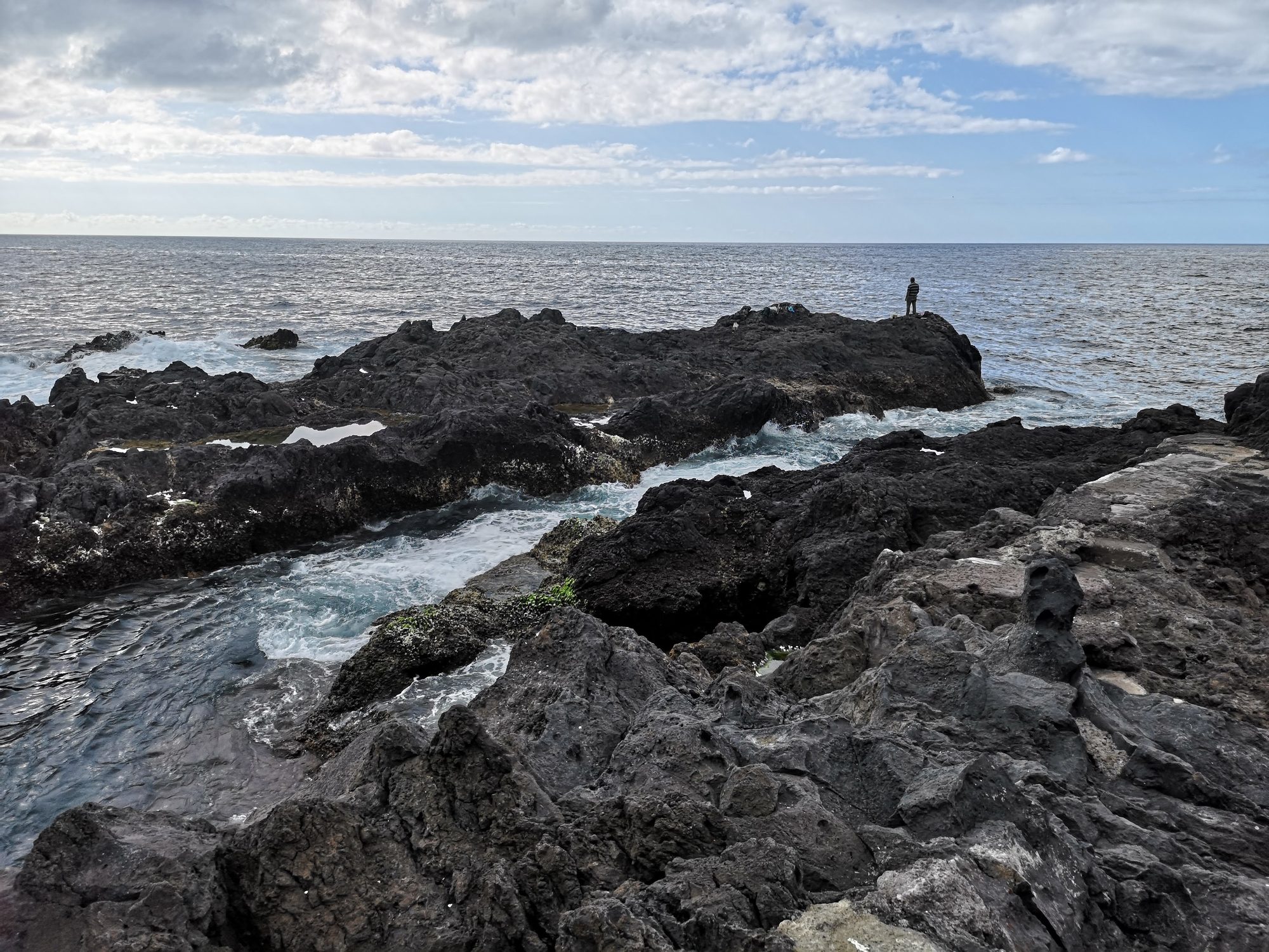 Costa de roca volcánica negra junto al mar con olas rompiendo en Garachico.
