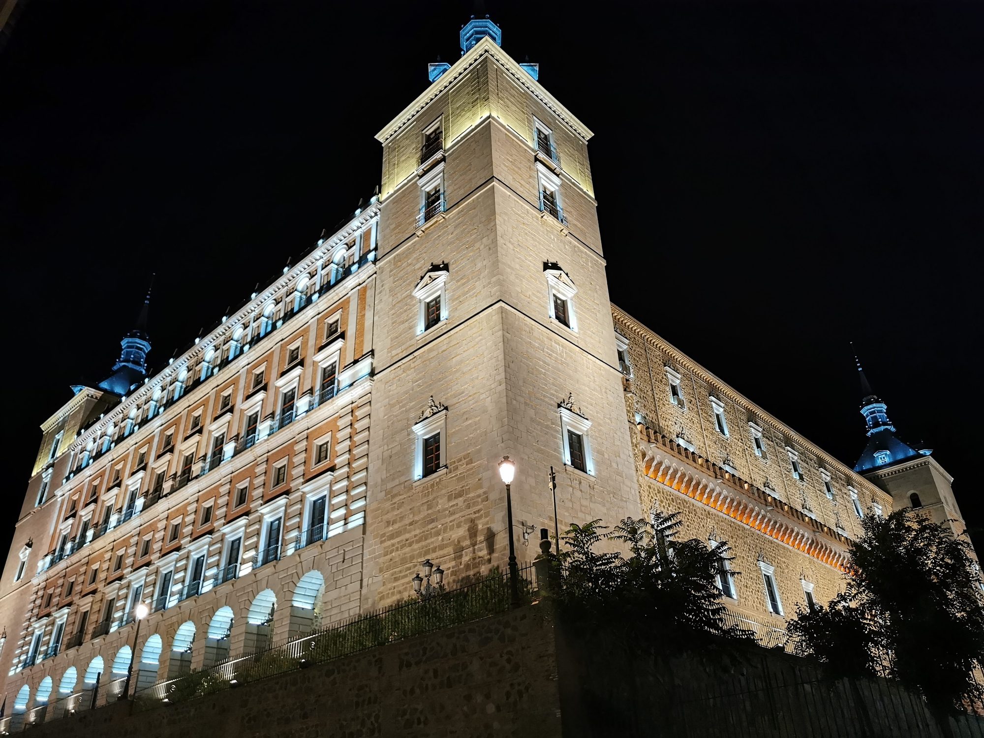 Fachada y torre del Alcázar de Toledo iluminadas durante la noche.