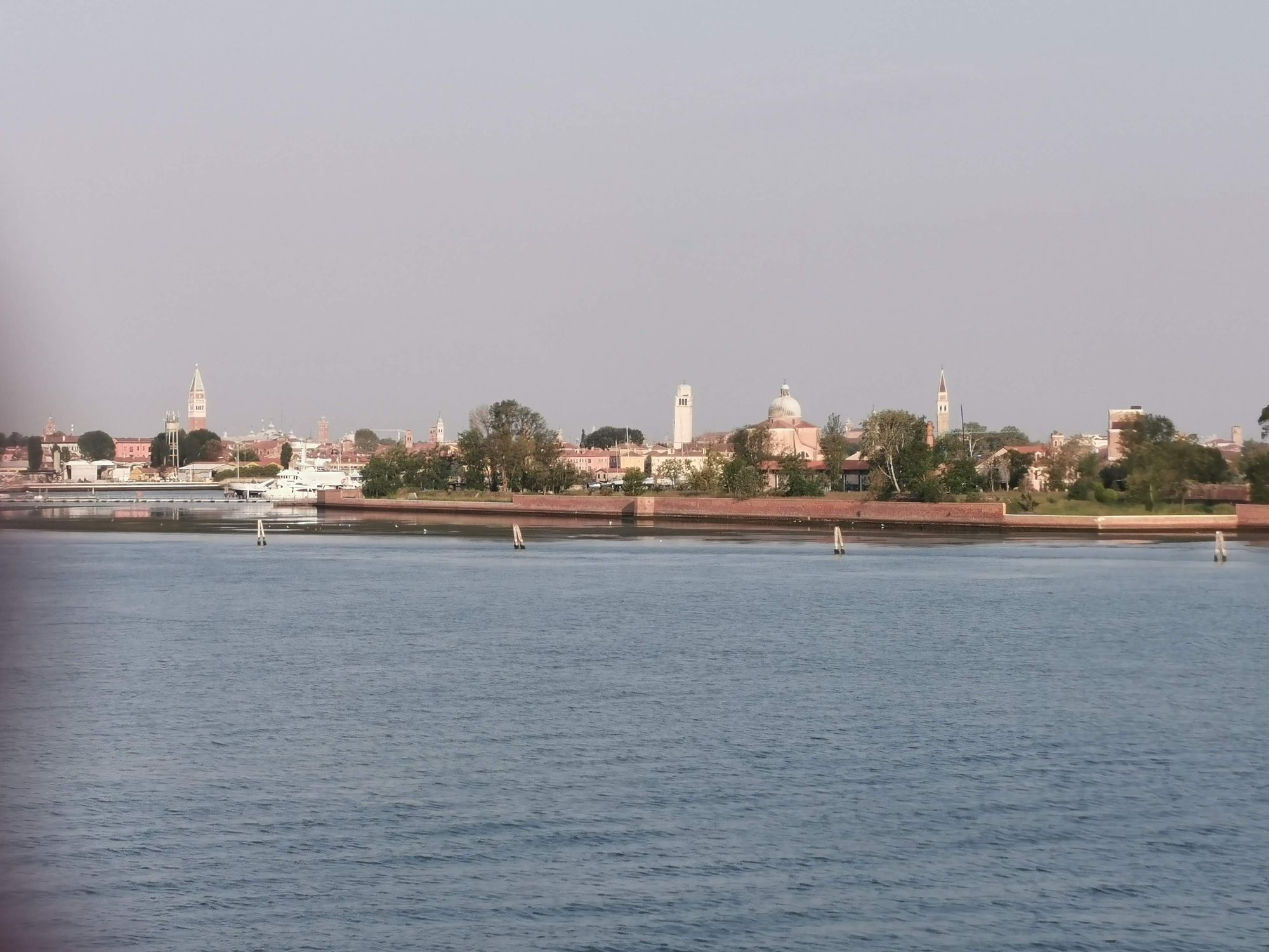 Panorámica de la laguna de Venecia con campanarios y edificios históricos en el horizonte.
