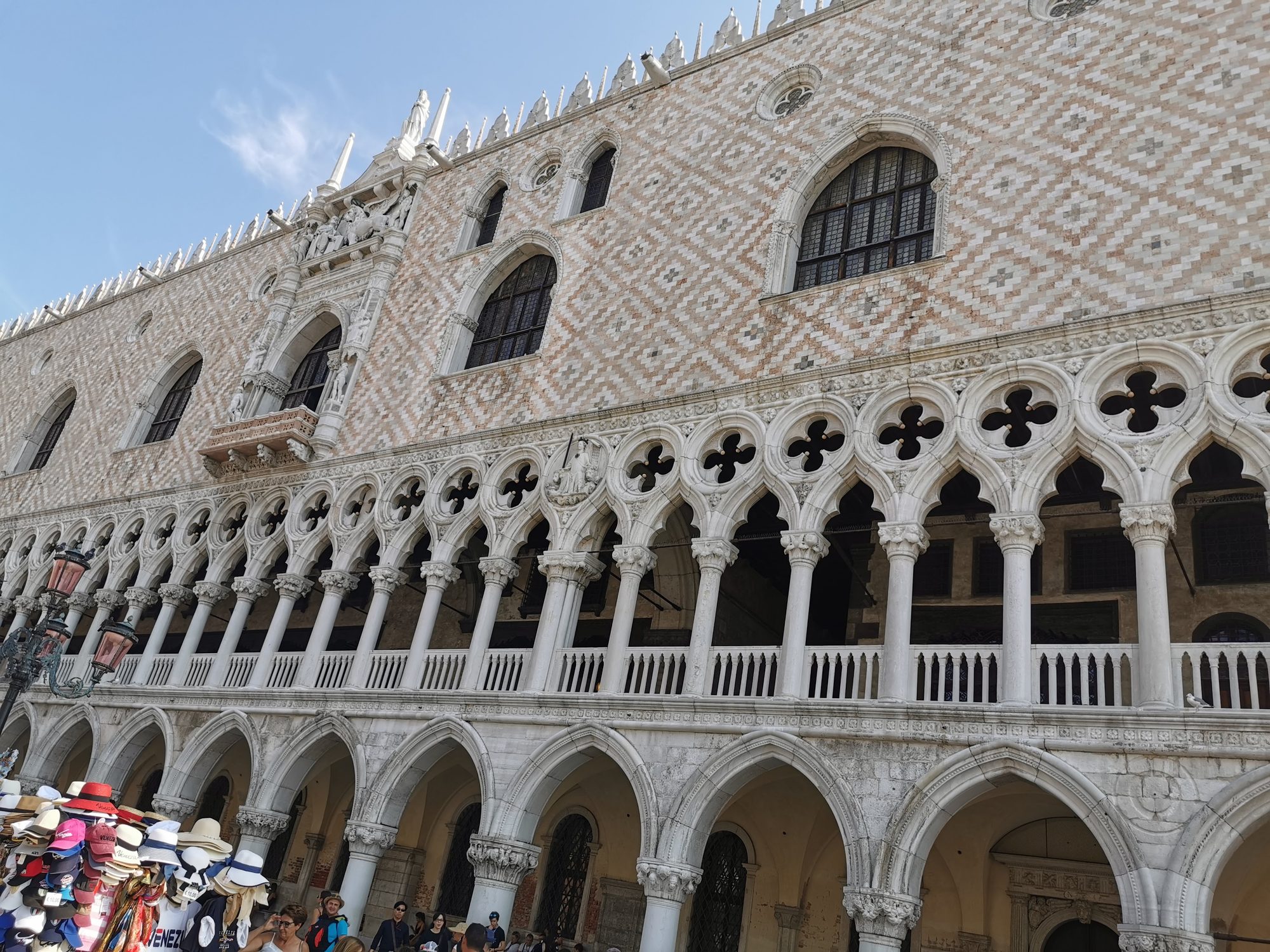 Fachada gótica del Palacio Ducal con arcadas y columnas de mármol en Venecia.