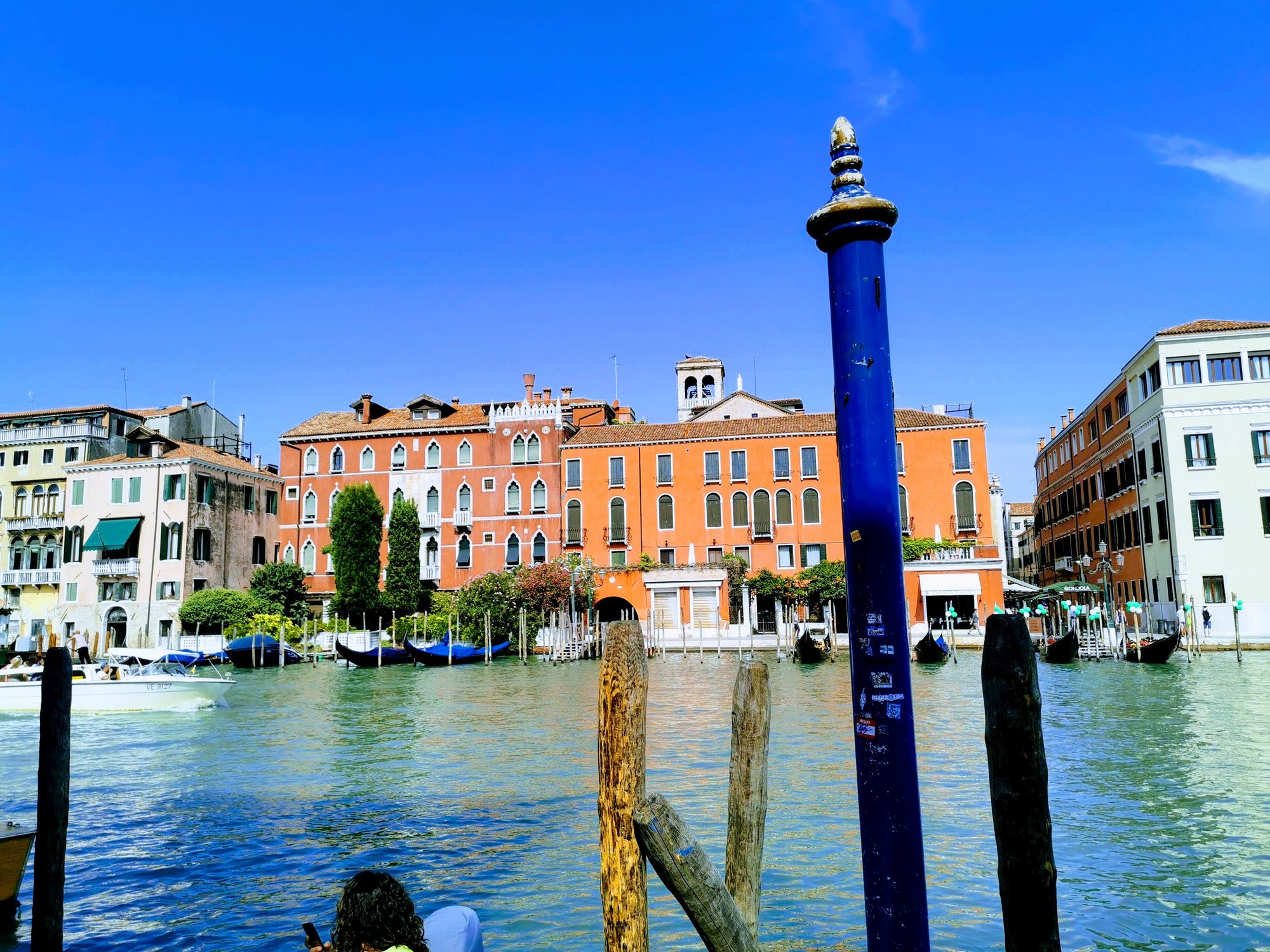 Edificios históricos y postes de amarre junto al Gran Canal en Venecia.