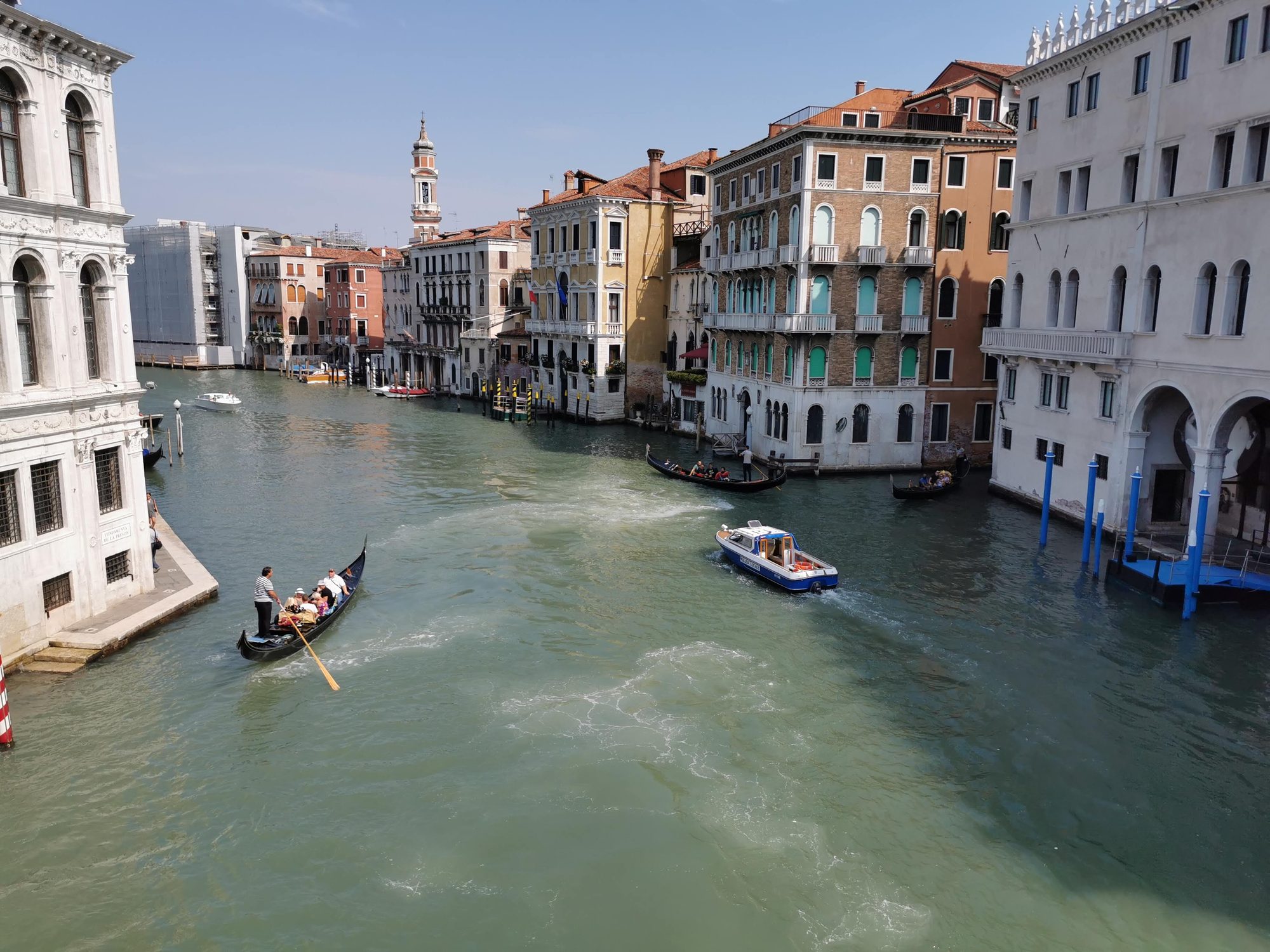 Góndolas y lanchas navegando por el Gran Canal rodeado de edificios históricos en Venecia.