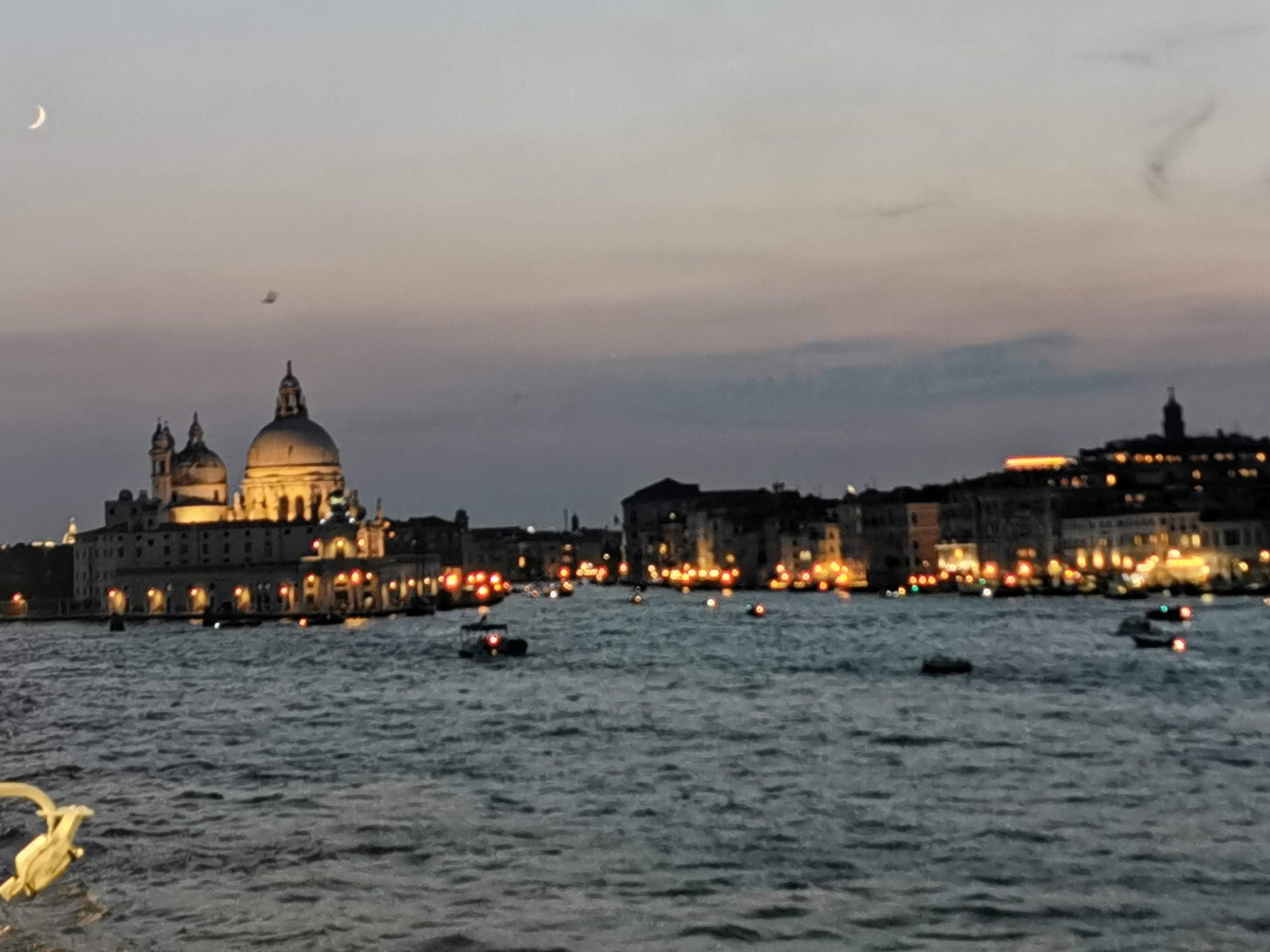 Basílica de Santa Maria della Salute iluminada al anochecer frente al agua en Venecia.