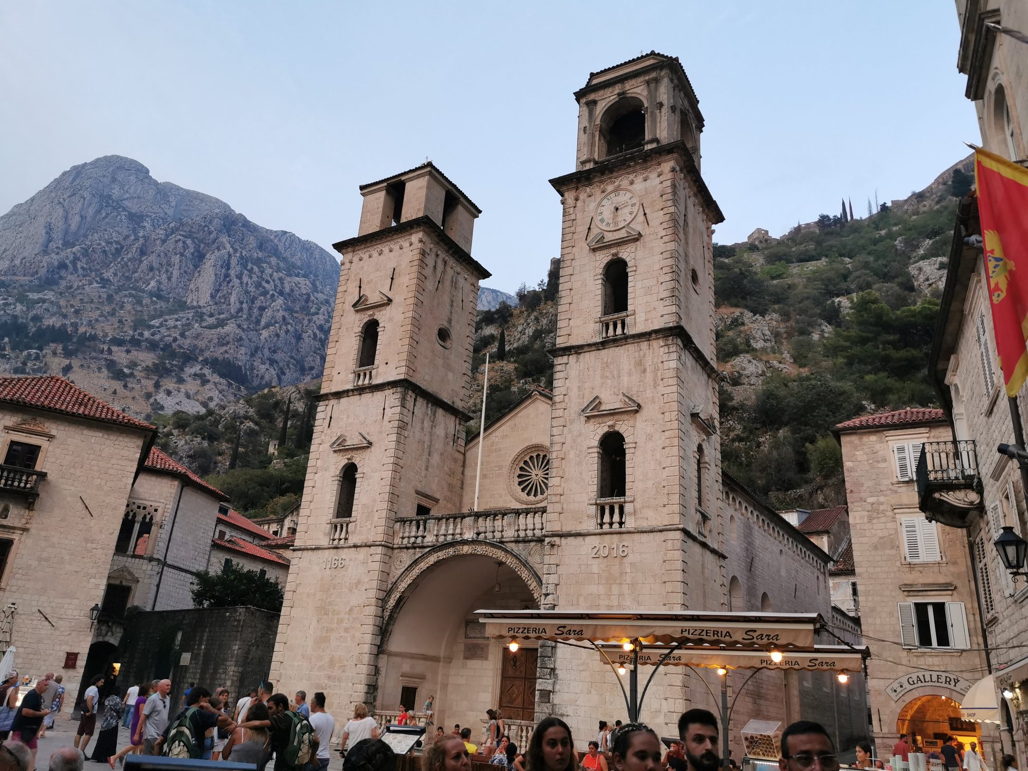 Catedral de San Trifón de piedra con dos torres frente a las montañas en Kotor.