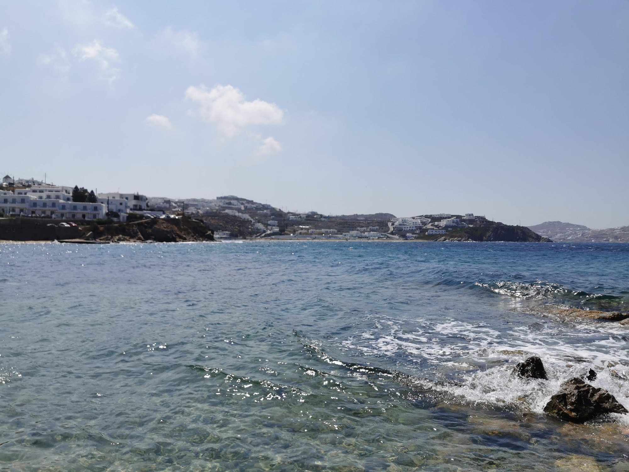 Aguas cristalinas del mar Egeo frente a la costa rocosa y blanca de Miconos.