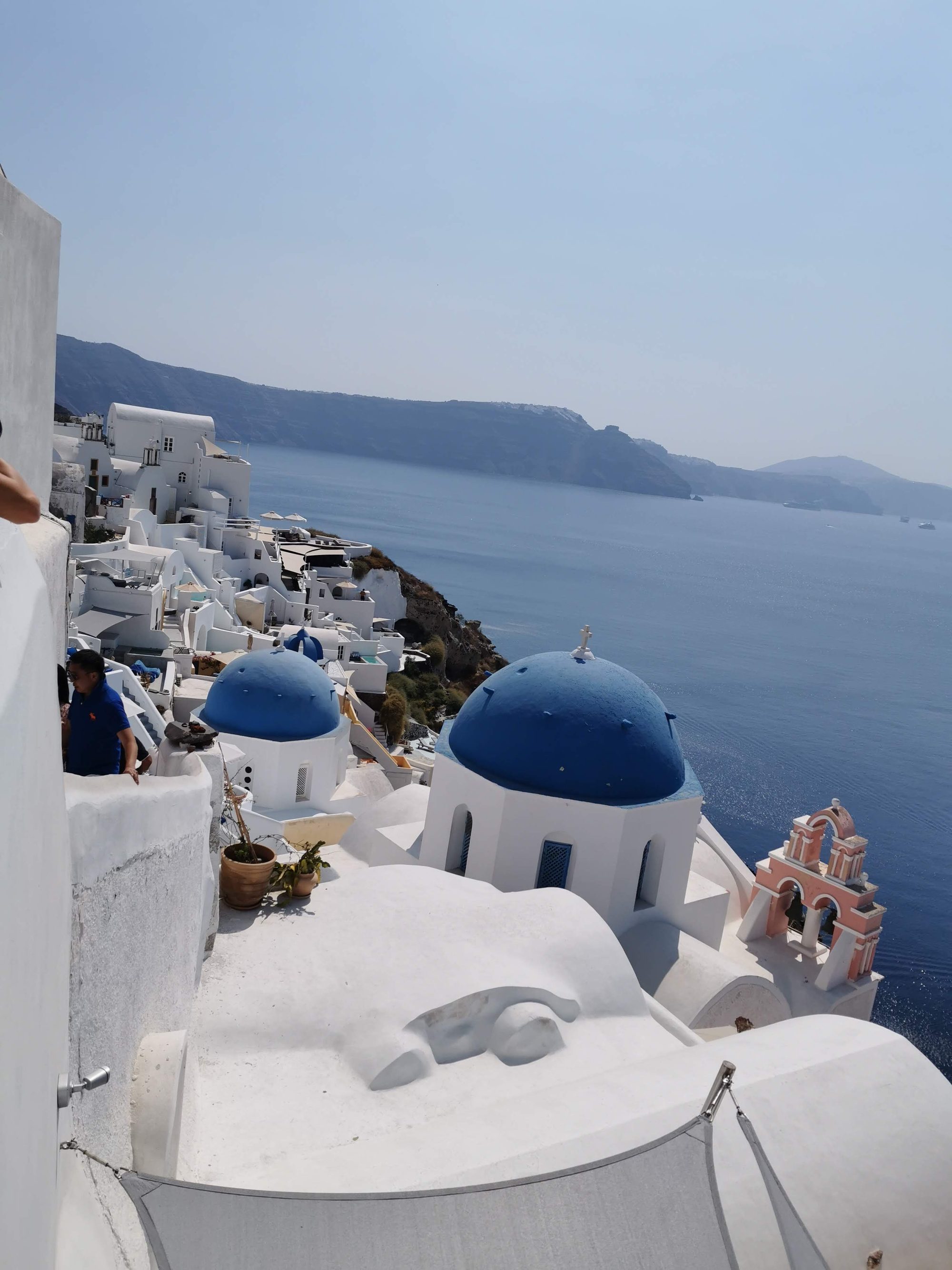 Cúpulas azules e iglesias encaladas sobre el acantilado frente al mar en Oia.
