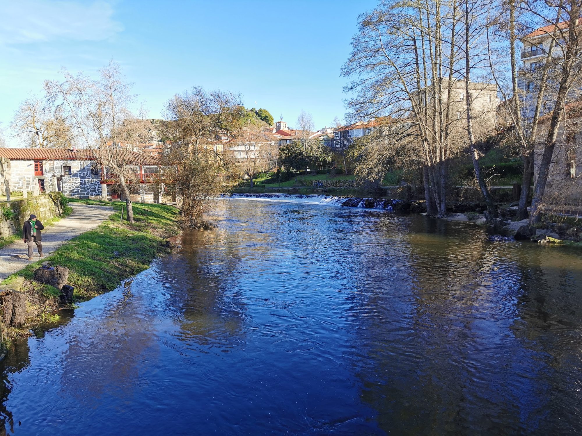 El río Arnoia a su paso por el pueblo histórico de Allariz entre árboles.