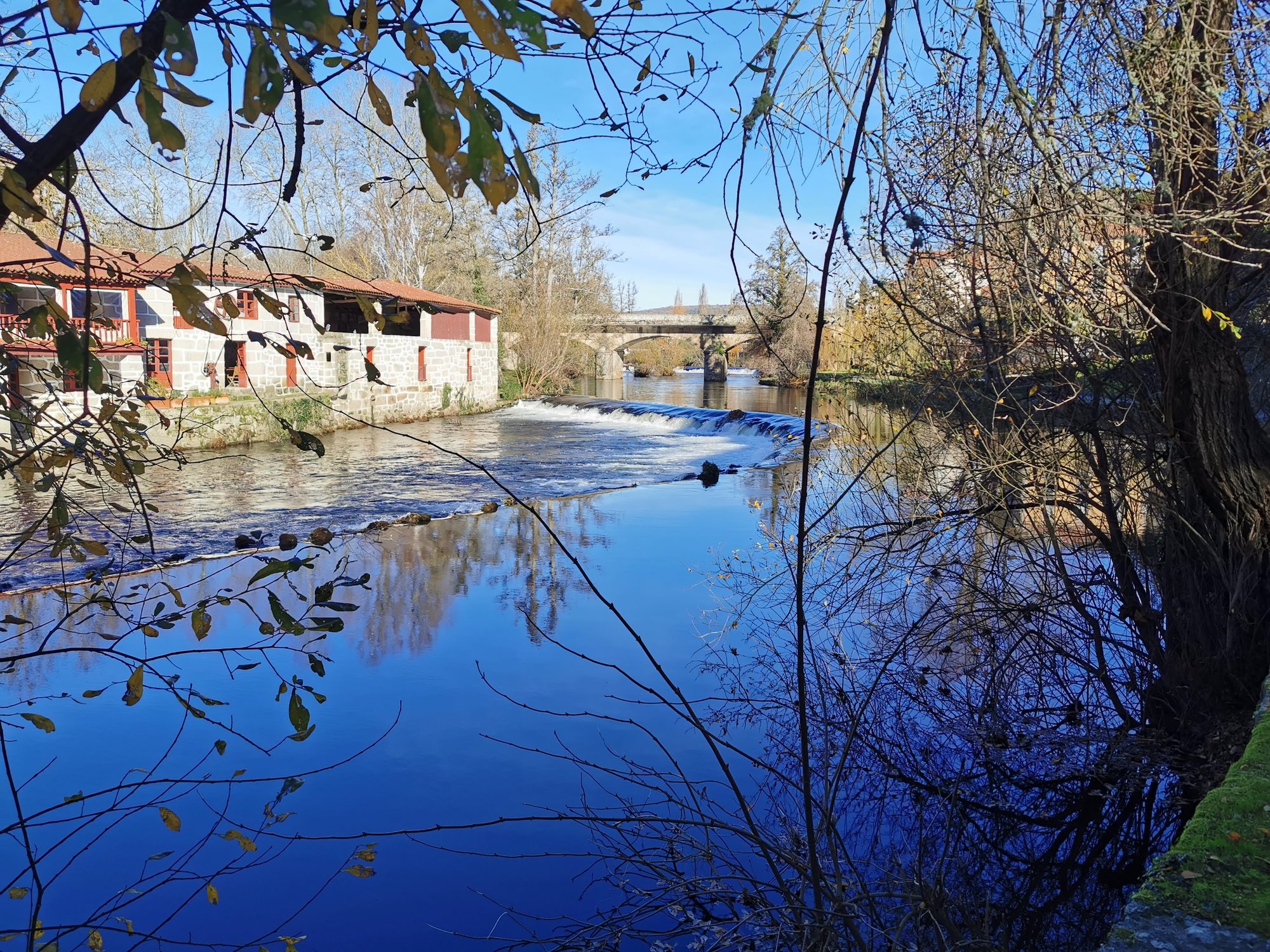 Río Arnoia en Allariz con molinos tradicionales de piedra y reflejos del agua.