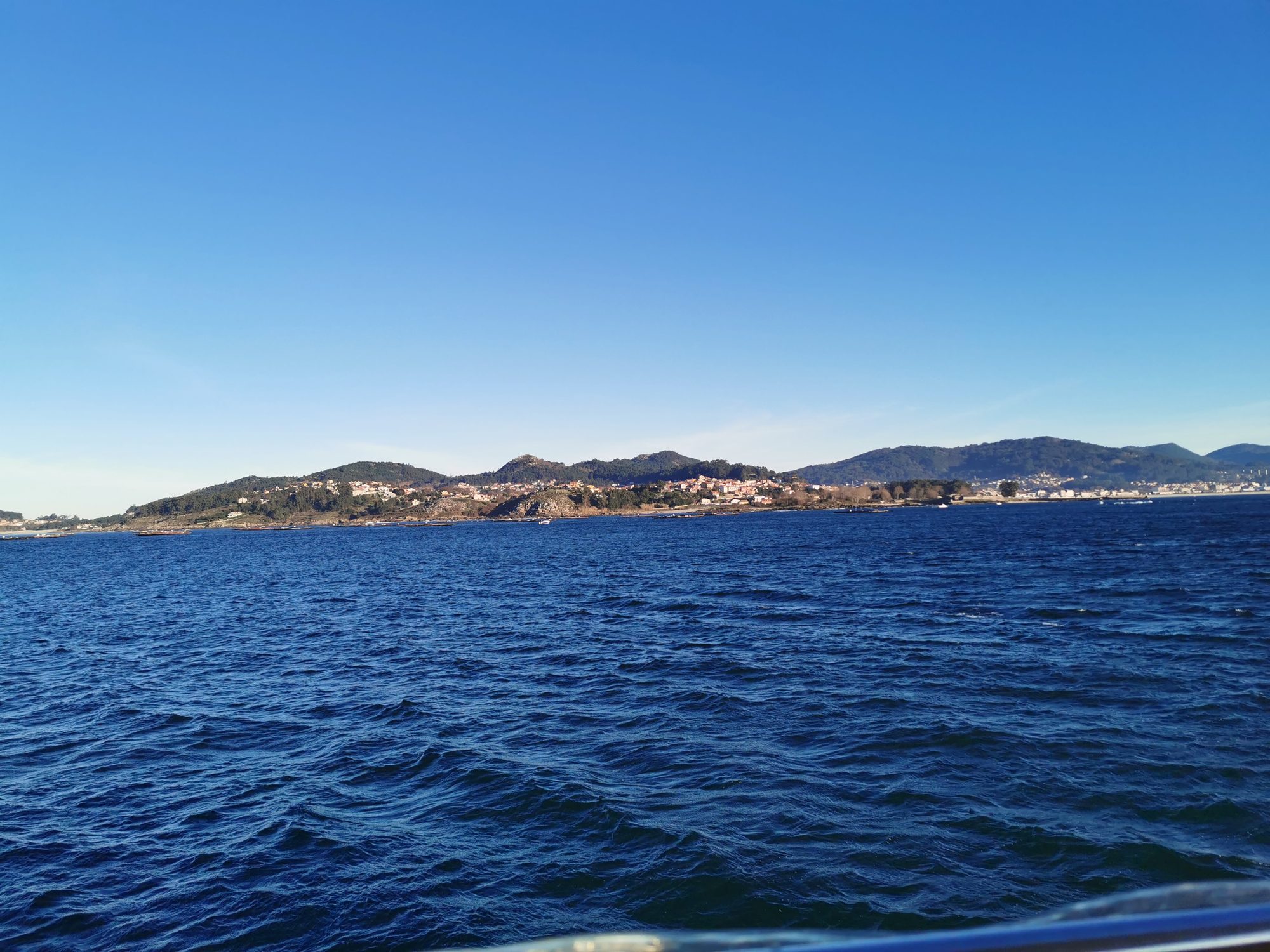 Vista de la costa montañosa de Cangas de Morrazo desde el mar azul.