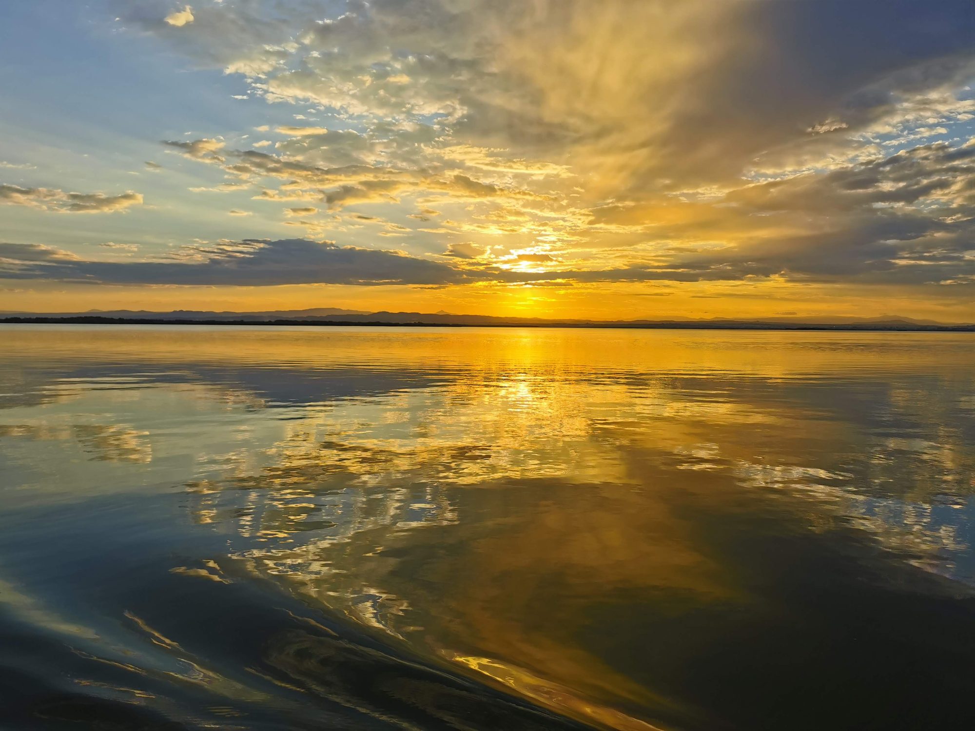 Atardecer dorado reflejado en las aguas tranquilas de la Albufera de Valencia.