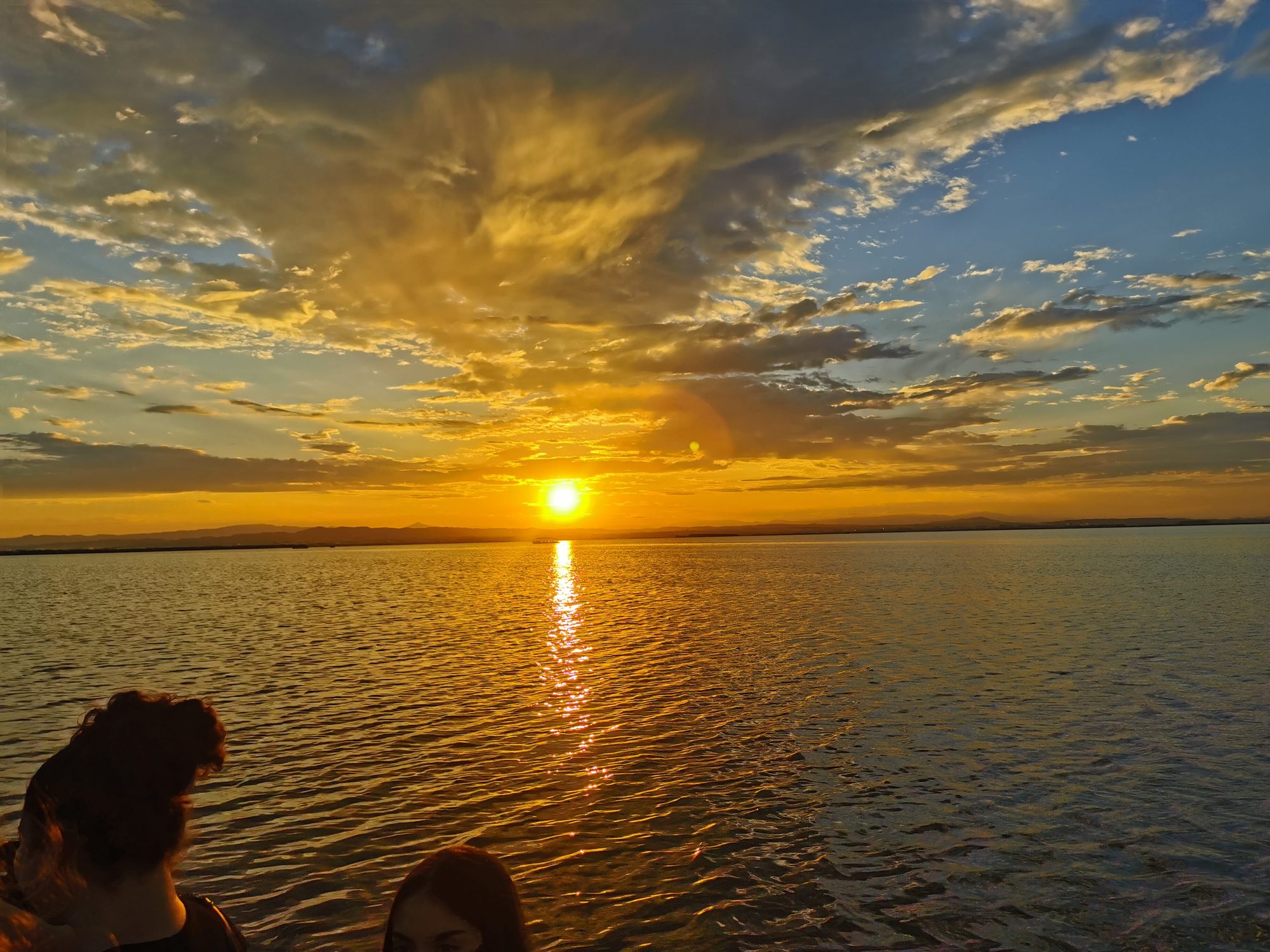 Puesta de sol dorada sobre las aguas tranquilas de la Albufera de Valencia.