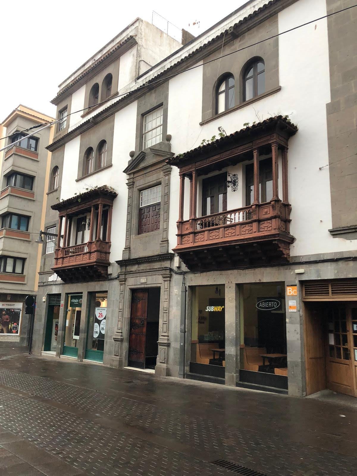 Edificio tradicional con balcones de madera tallada en una calle de Puerto de la Cruz.