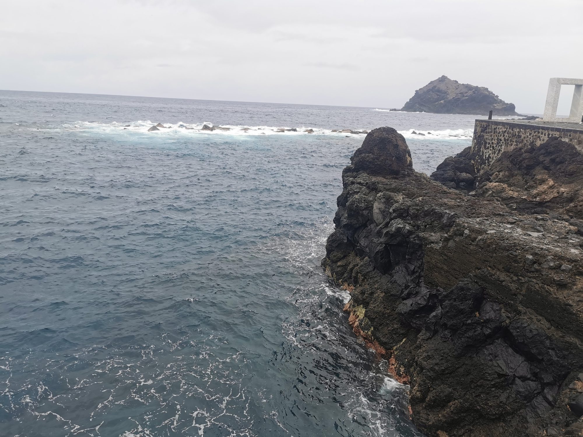 Acantilados de roca volcánica y oleaje frente al mar en la costa de Garachico.