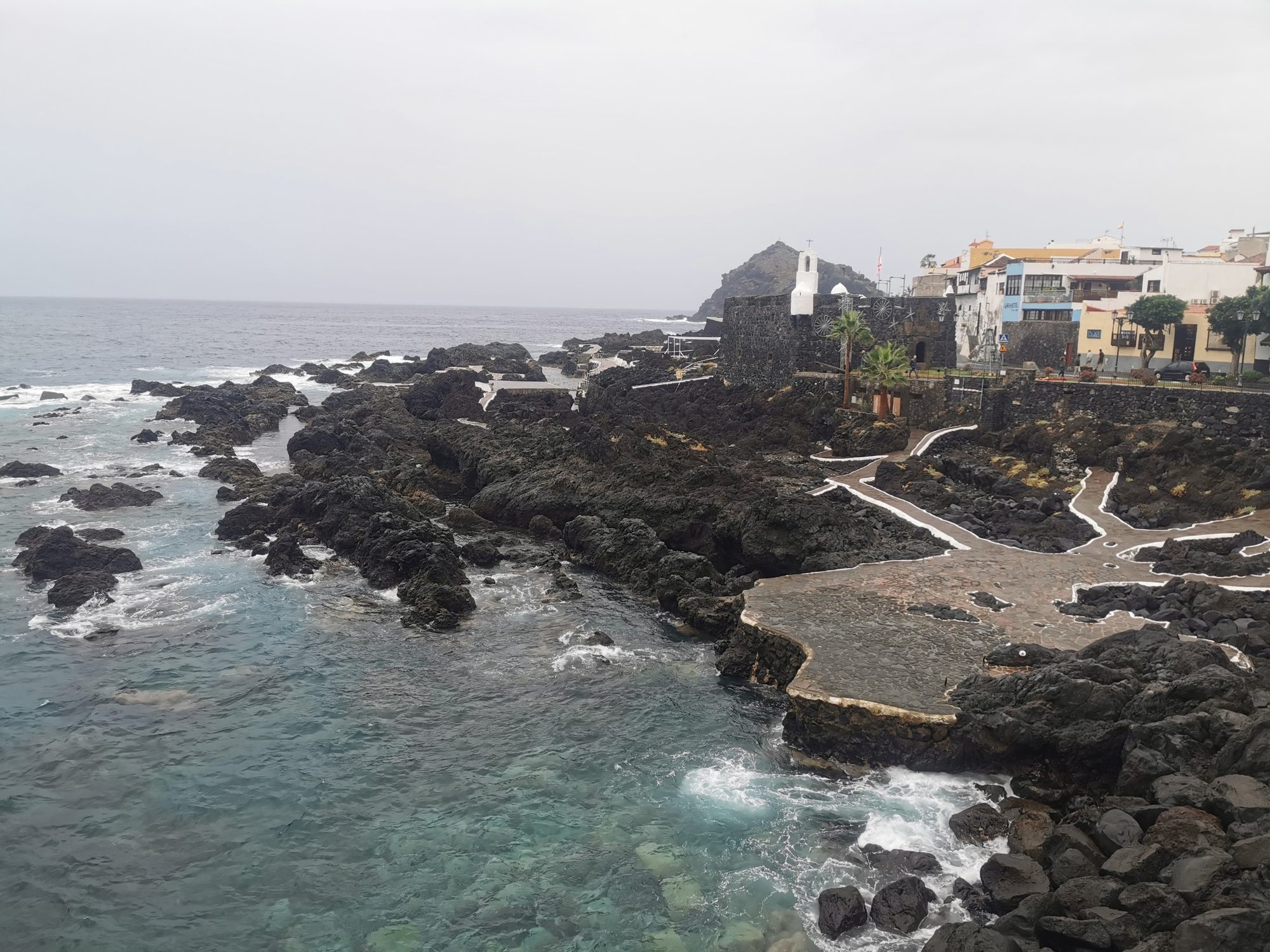 Piscinas naturales de roca volcánica y castillo histórico en la costa de Garachico.