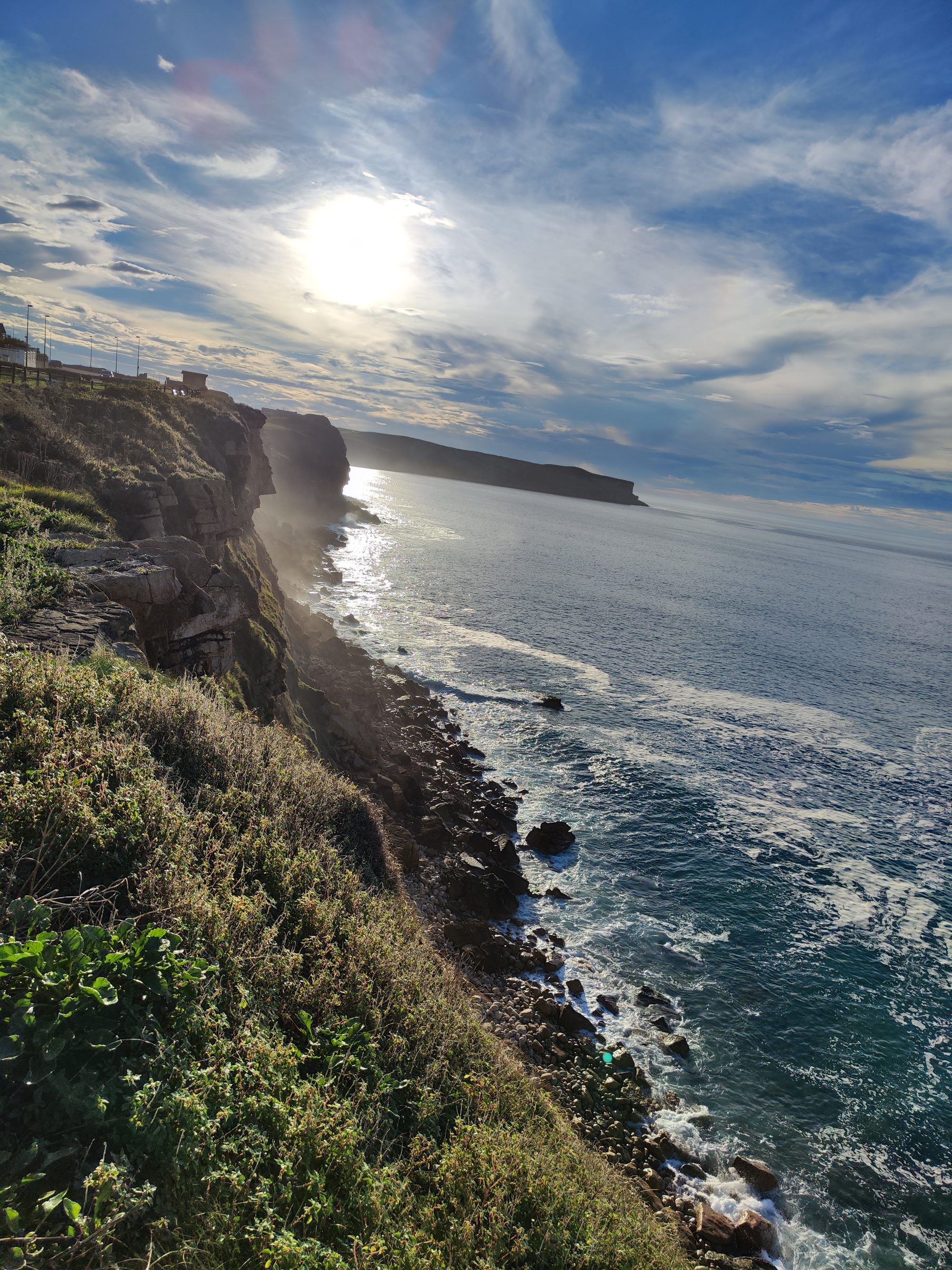 Acantilados rocosos junto al mar Cantábrico bajo un cielo soleado y despejado en Suances.