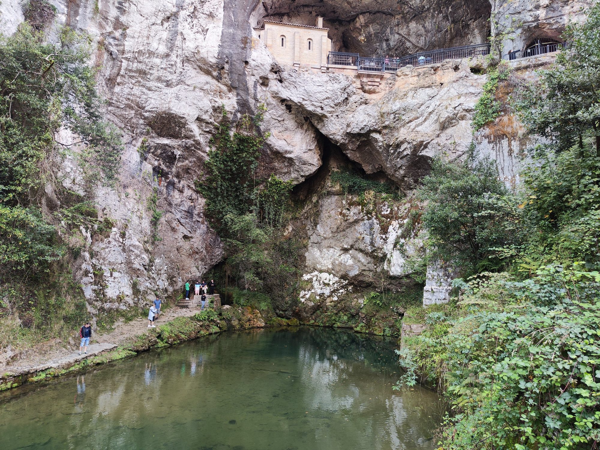 Santa Cueva de Covadonga enclavada en la roca sobre un estanque de agua cristalina