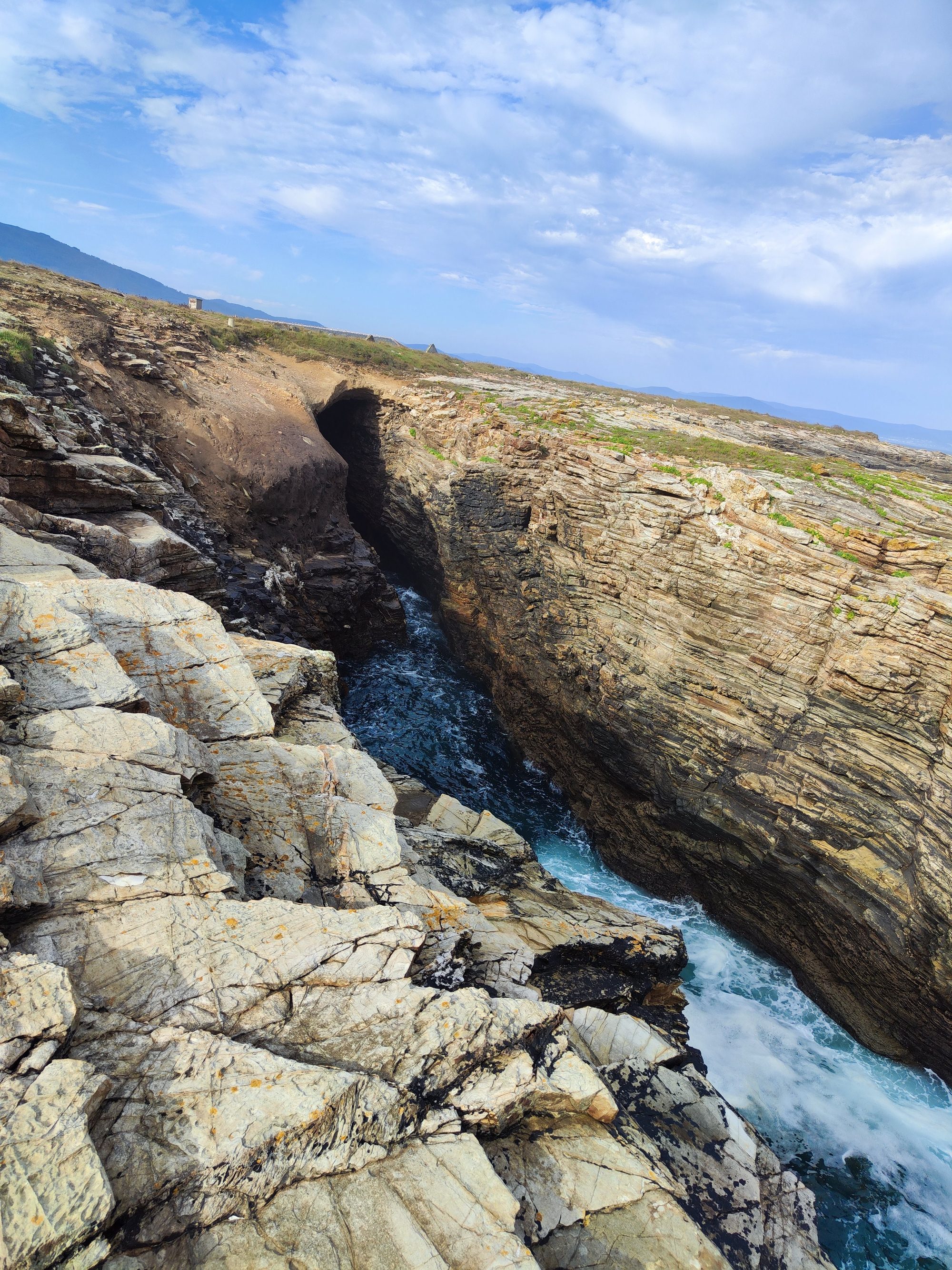 Acantilados rocosos y una grieta marina natural en la costa cantábrica.