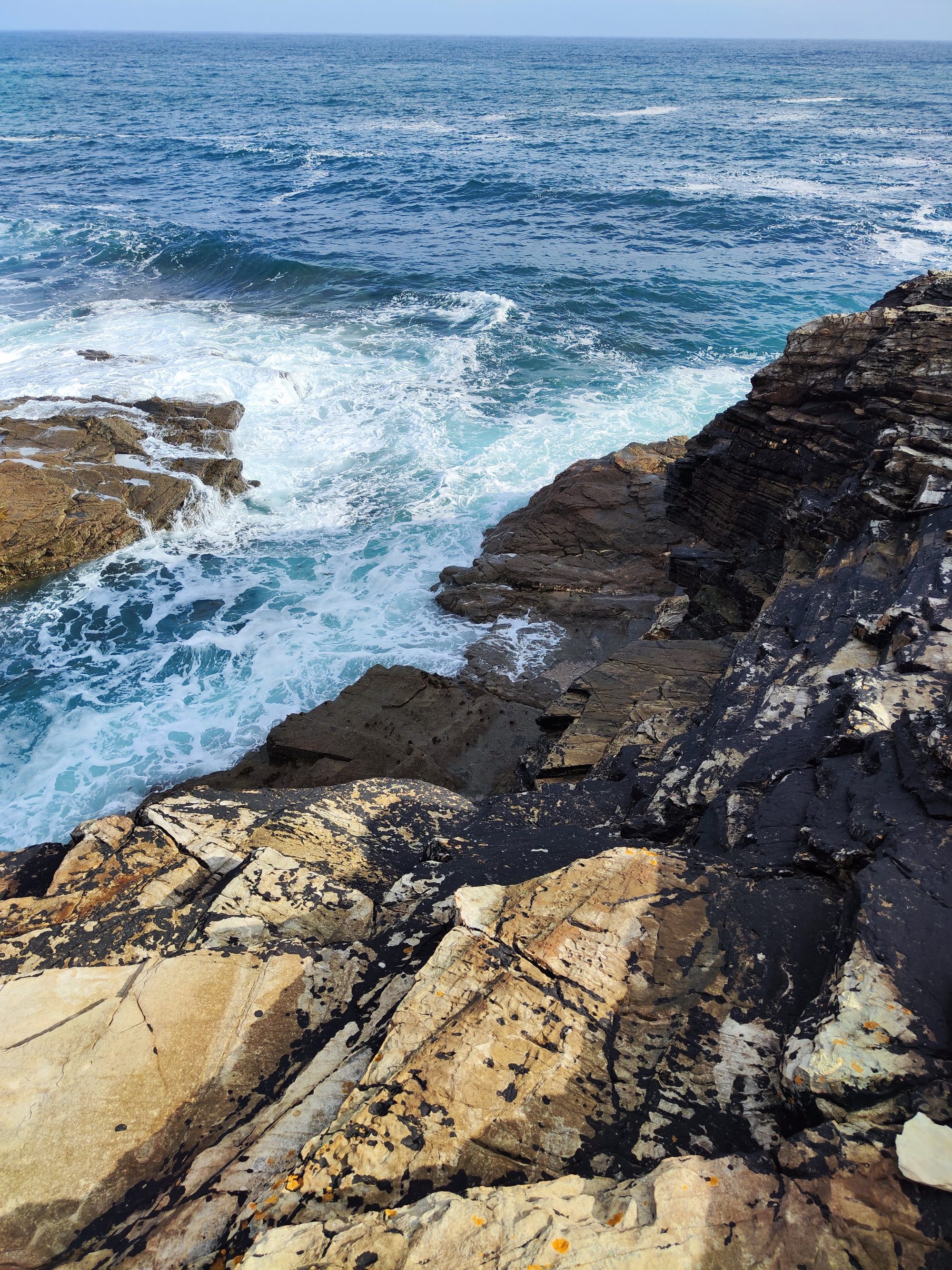 Olas del mar Cantábrico rompiendo contra los acantilados rocosos de la costa.