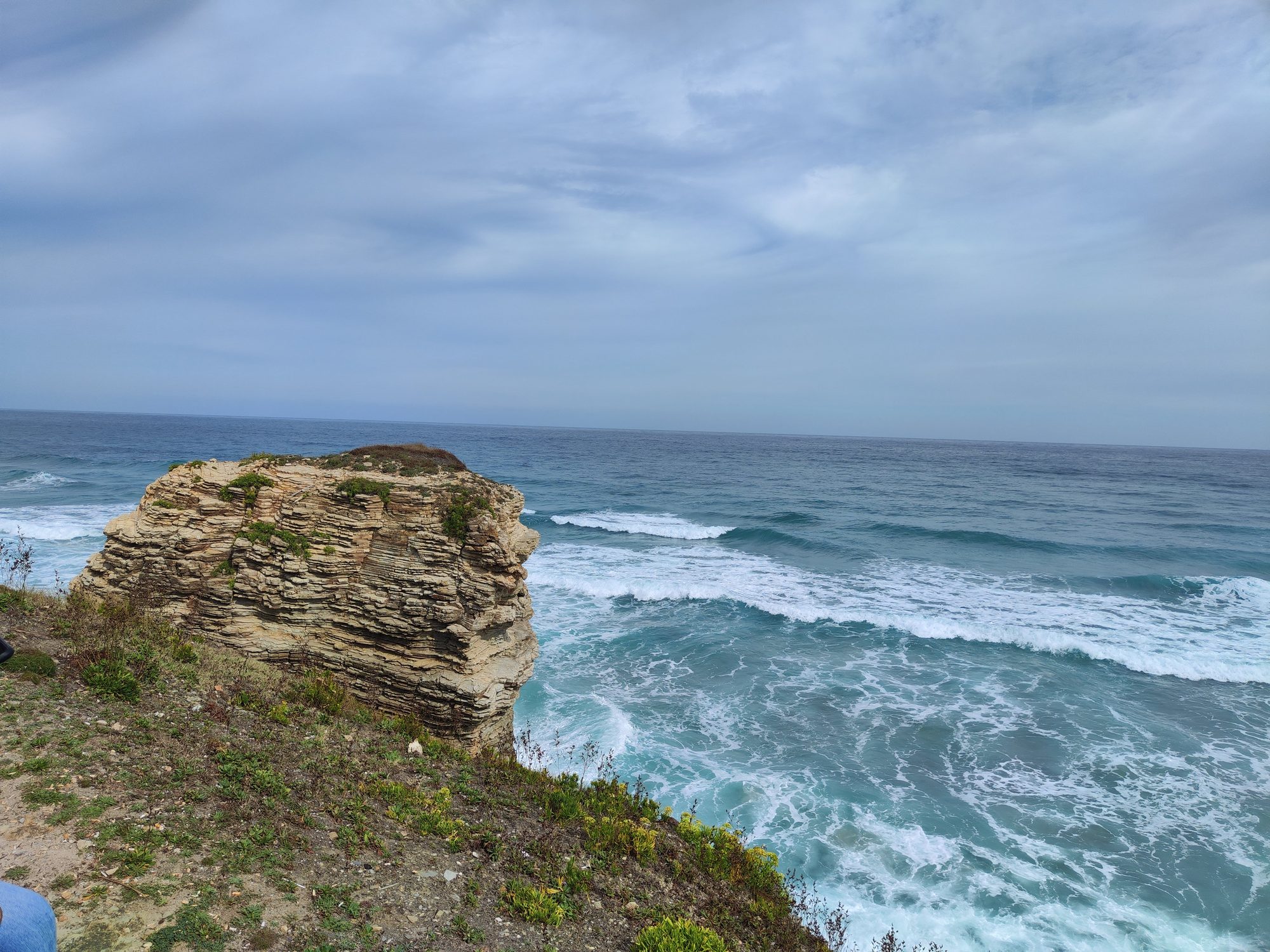 Acantilado rocoso junto al mar Cantábrico con olas rompiendo en la costa de Ribadeo.