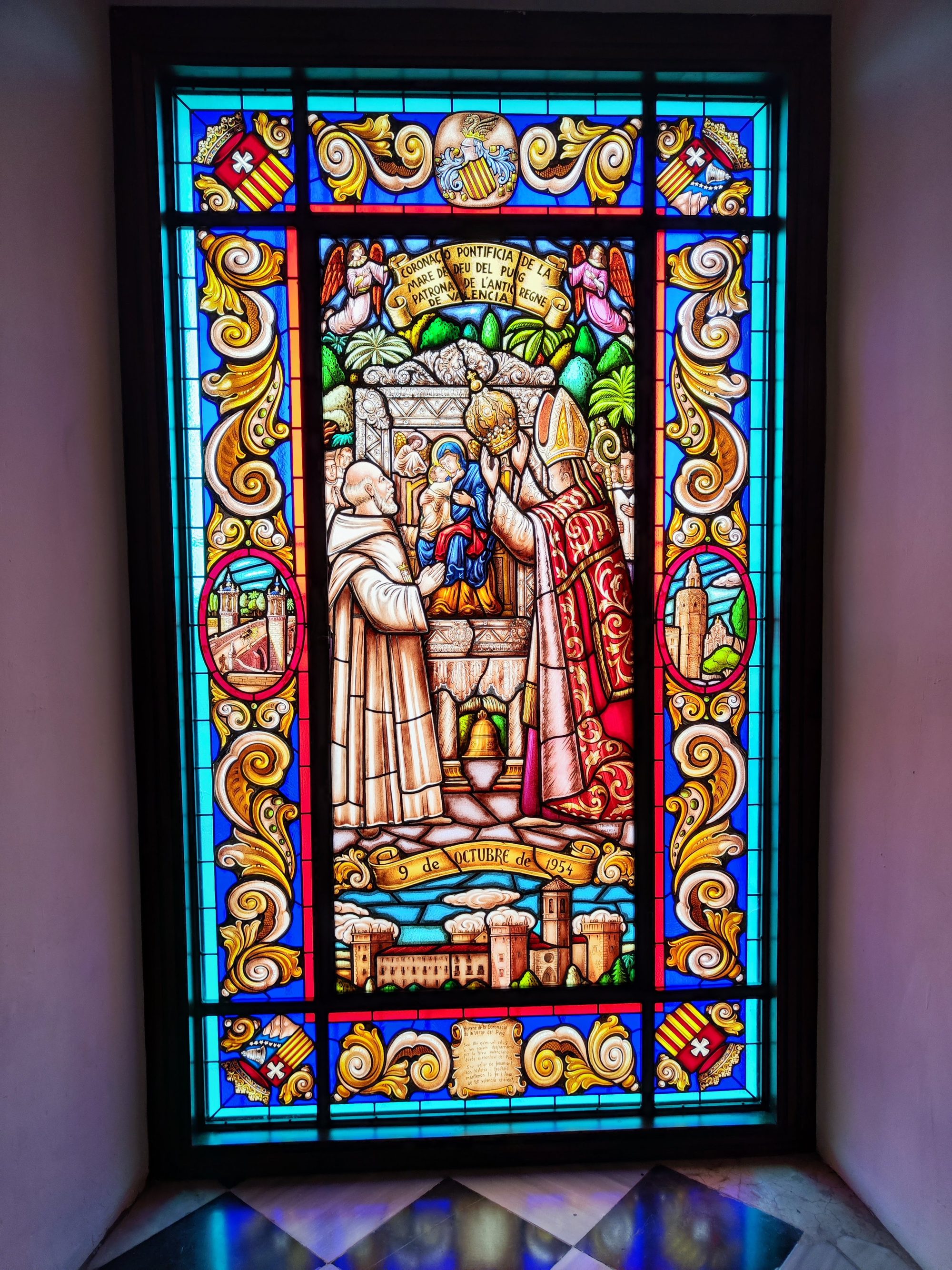 Vidriera de colores detallada que muestra la coronación de la Virgen del Puig.