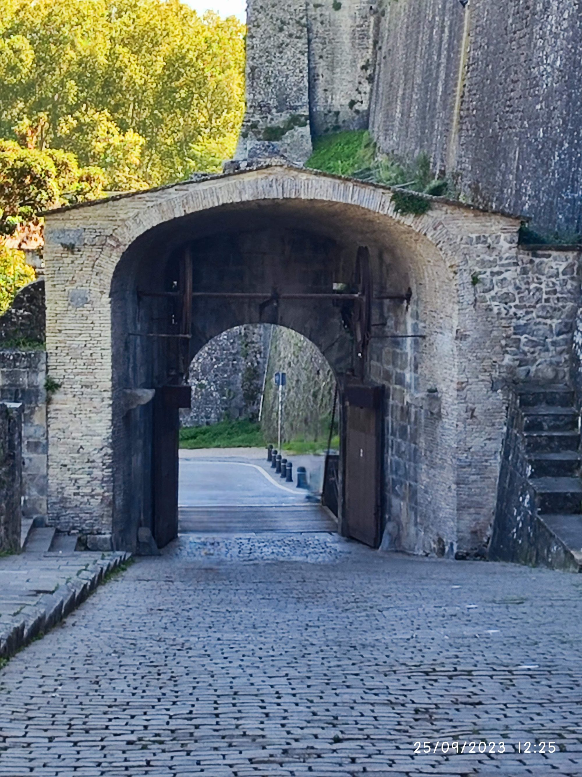 Arco de piedra histórico y camino empedrado en las viejas murallas de Pamplona.