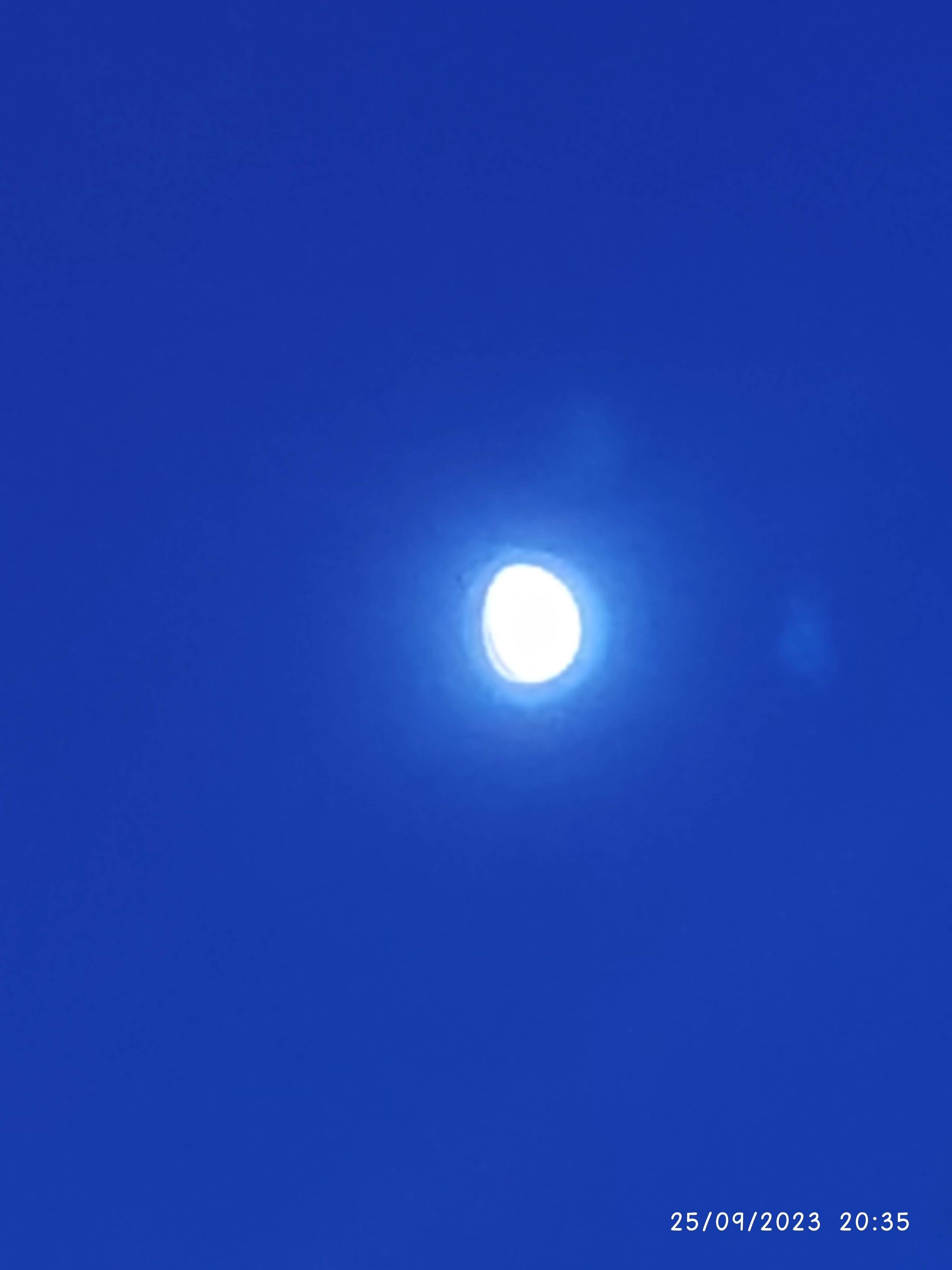 Luna brillante destacando en un cielo nocturno de color azul profundo.