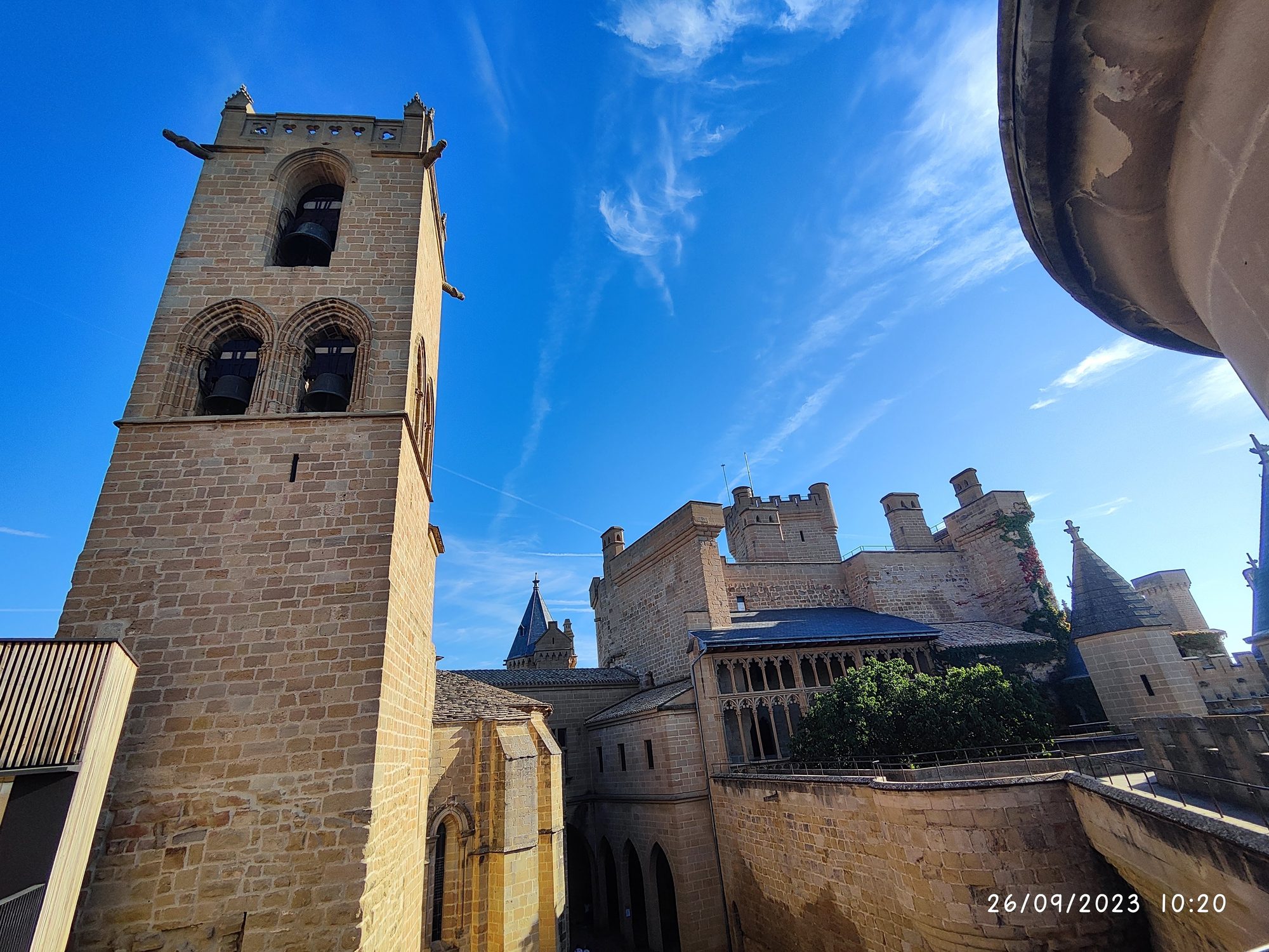 Torre de piedra medieval del Castillo de Olite bajo un cielo azul despejado.