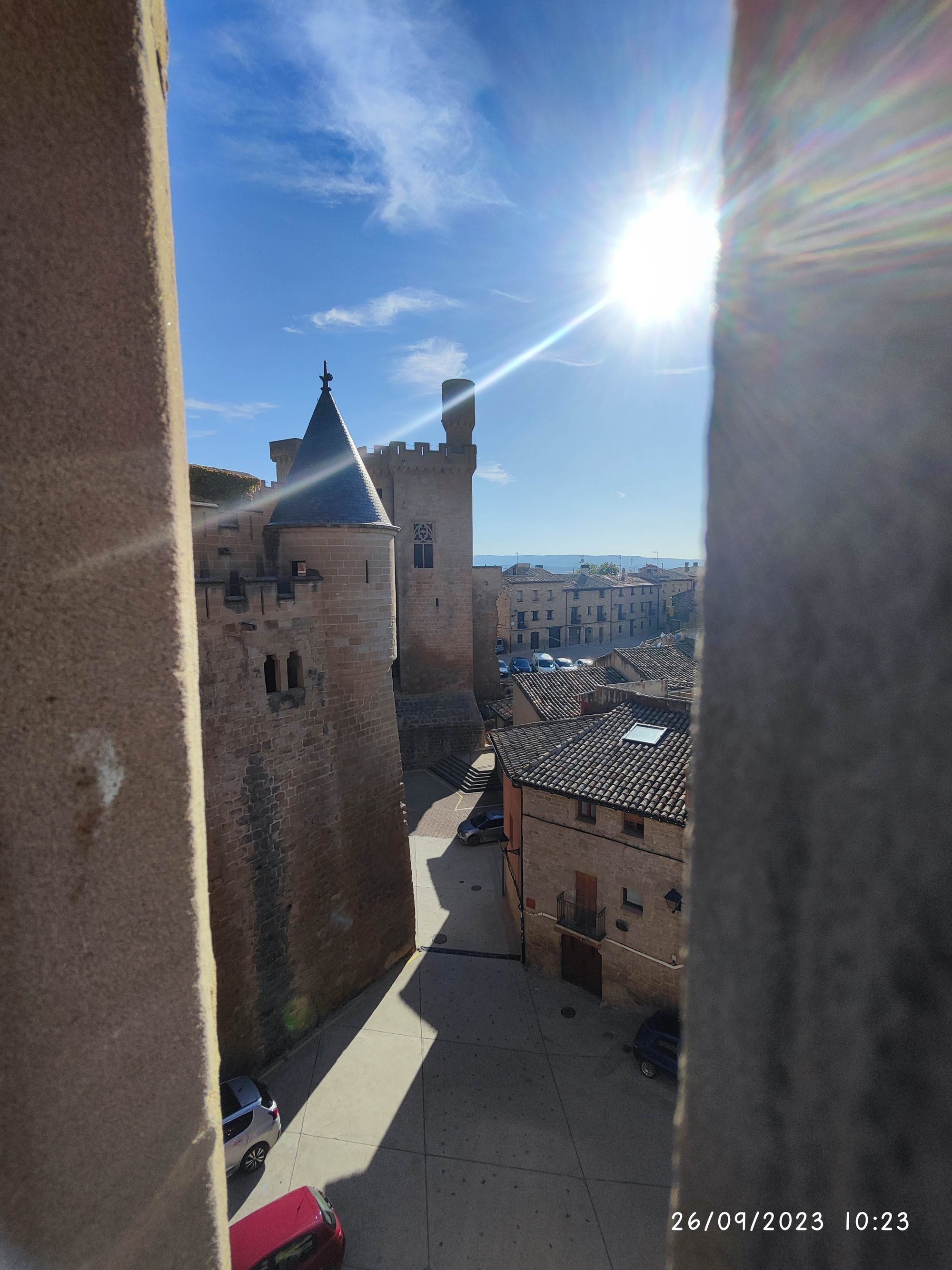 Vista desde el Palacio Real de Olite con torres medievales bajo un sol radiante.