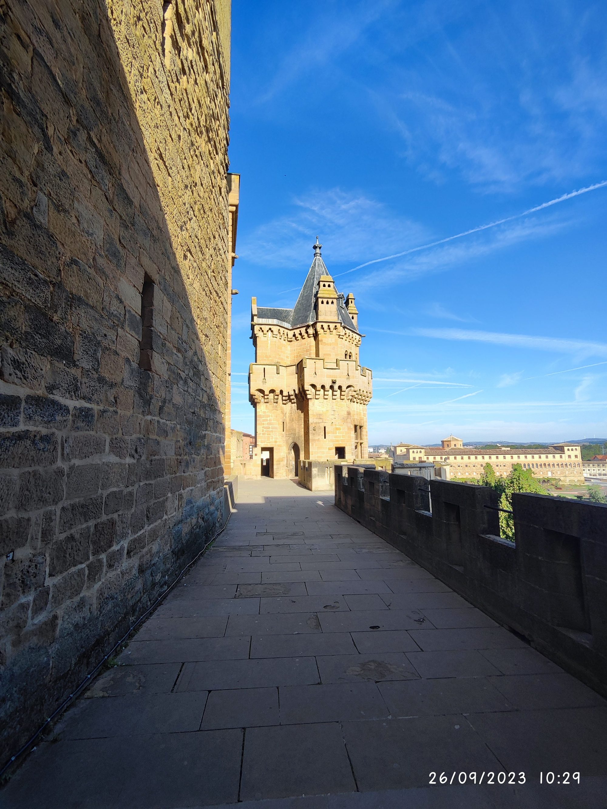 Torre medieval de piedra y adarve del castillo de Olite bajo un cielo despejado.
