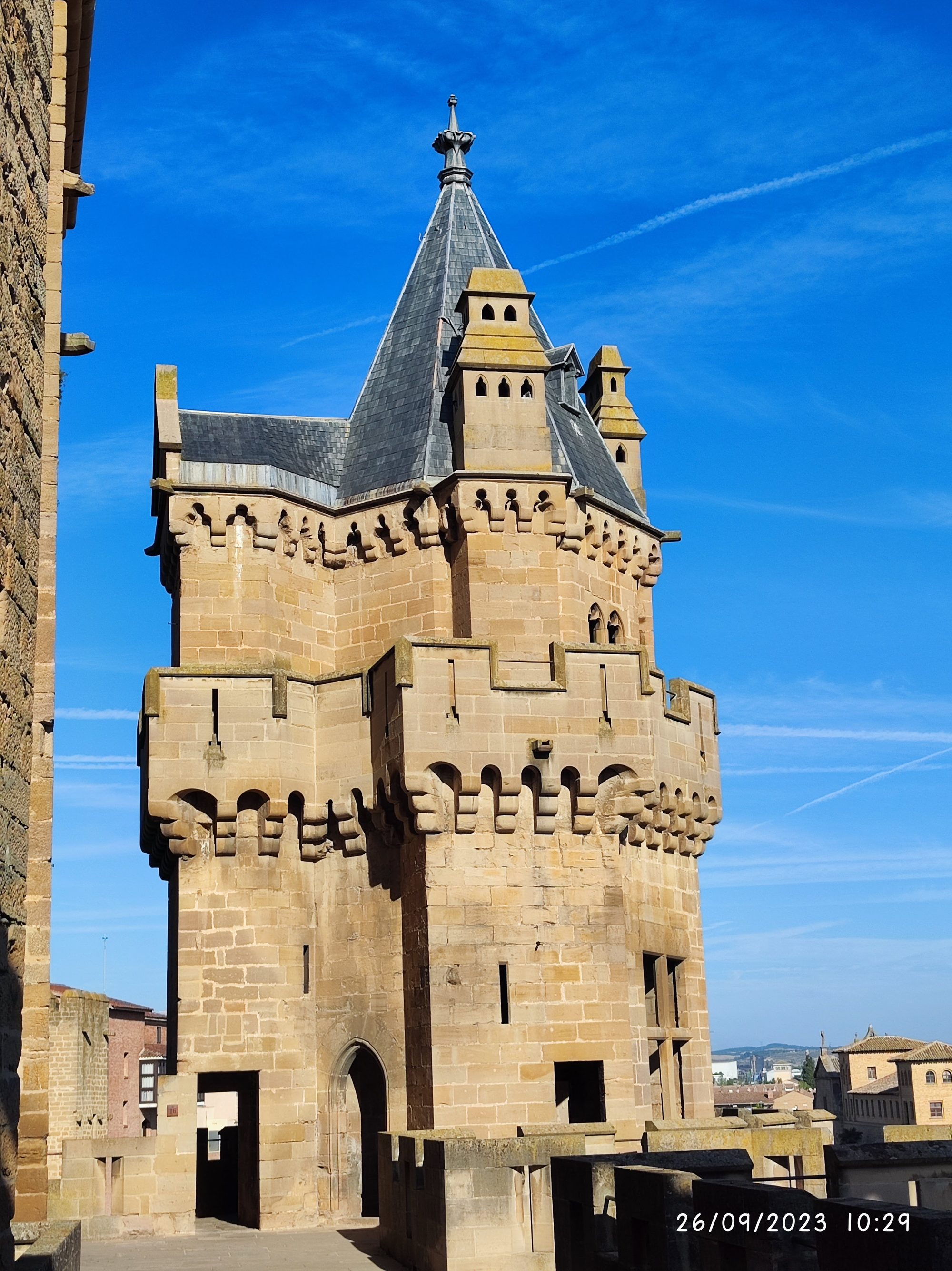 Torre de piedra medieval del Palacio Real de Olite bajo un cielo azul despejado.