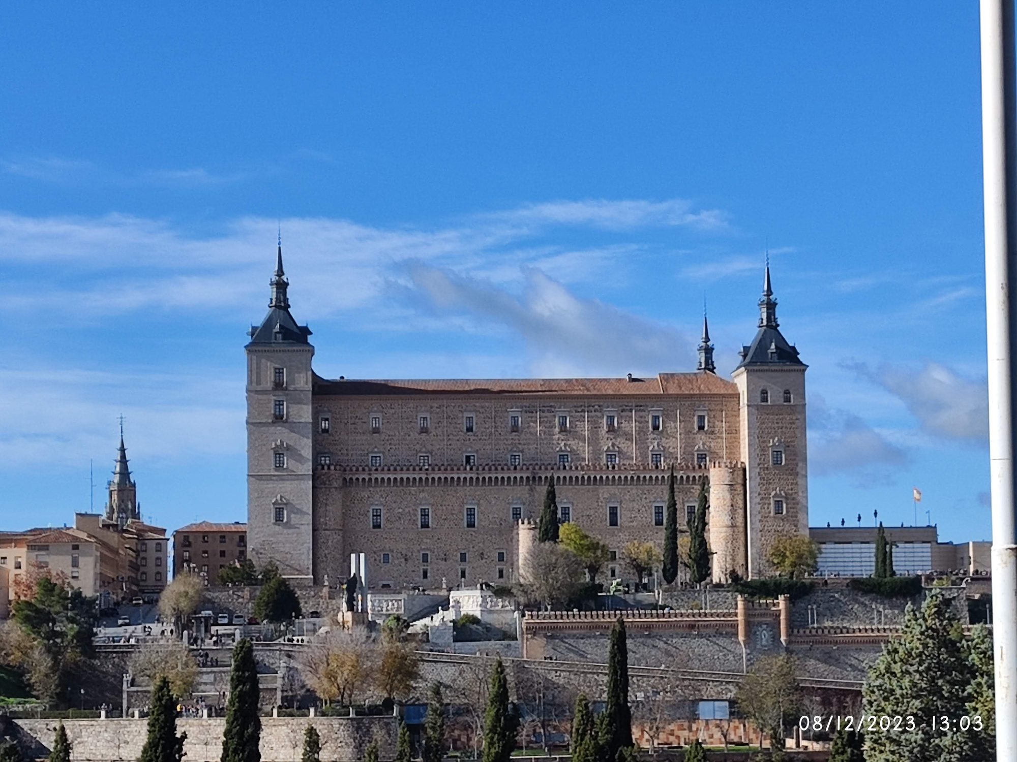 Vista panorámica del Alcázar de Toledo bajo un cielo azul despejado.