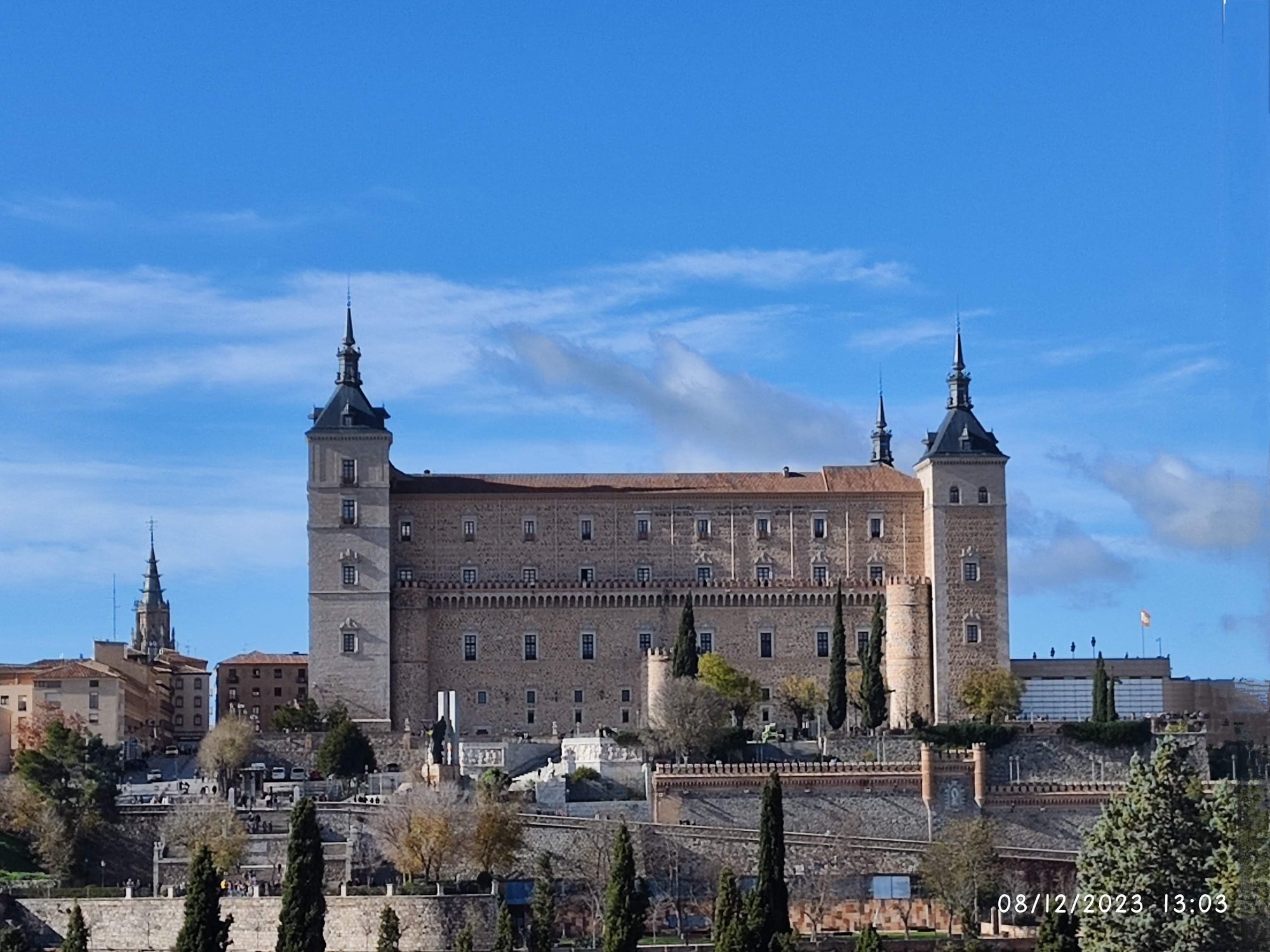 Vista frontal del imponente Alcázar de Toledo bajo un cielo azul despejado.