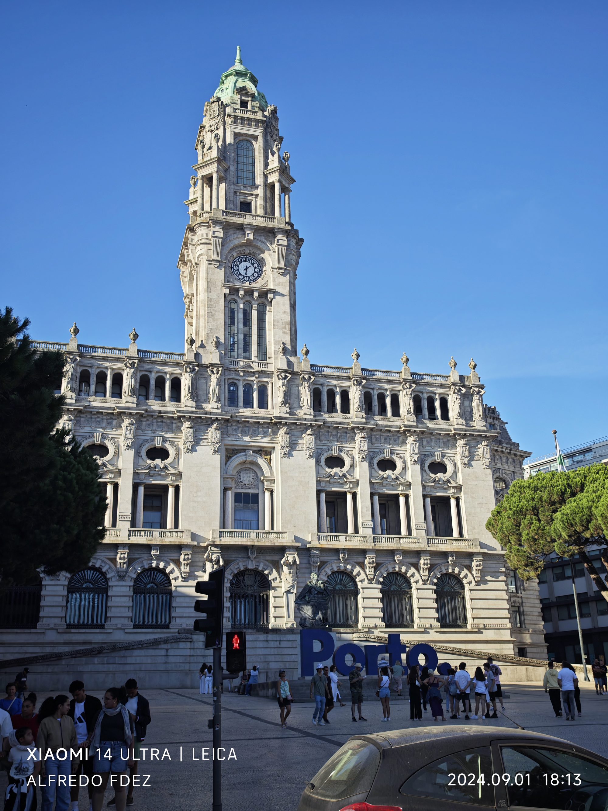 Fachada del Ayuntamiento de Oporto y su torre del reloj bajo un cielo despejado.