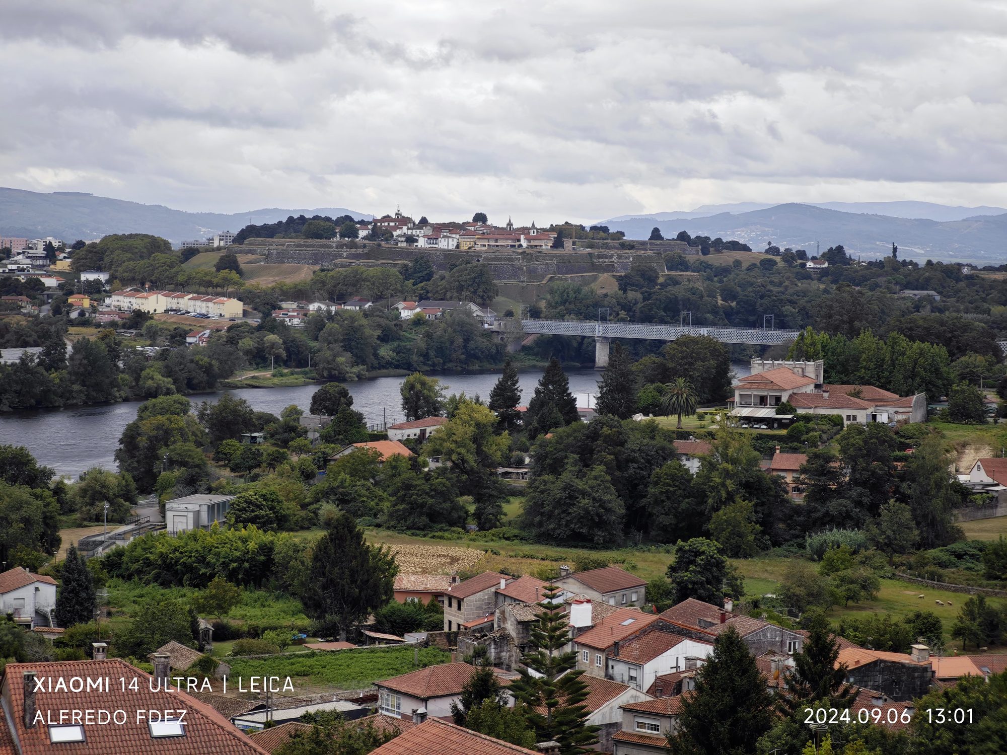 Vista del río Miño y el puente internacional rodeado de vegetación desde Tui.