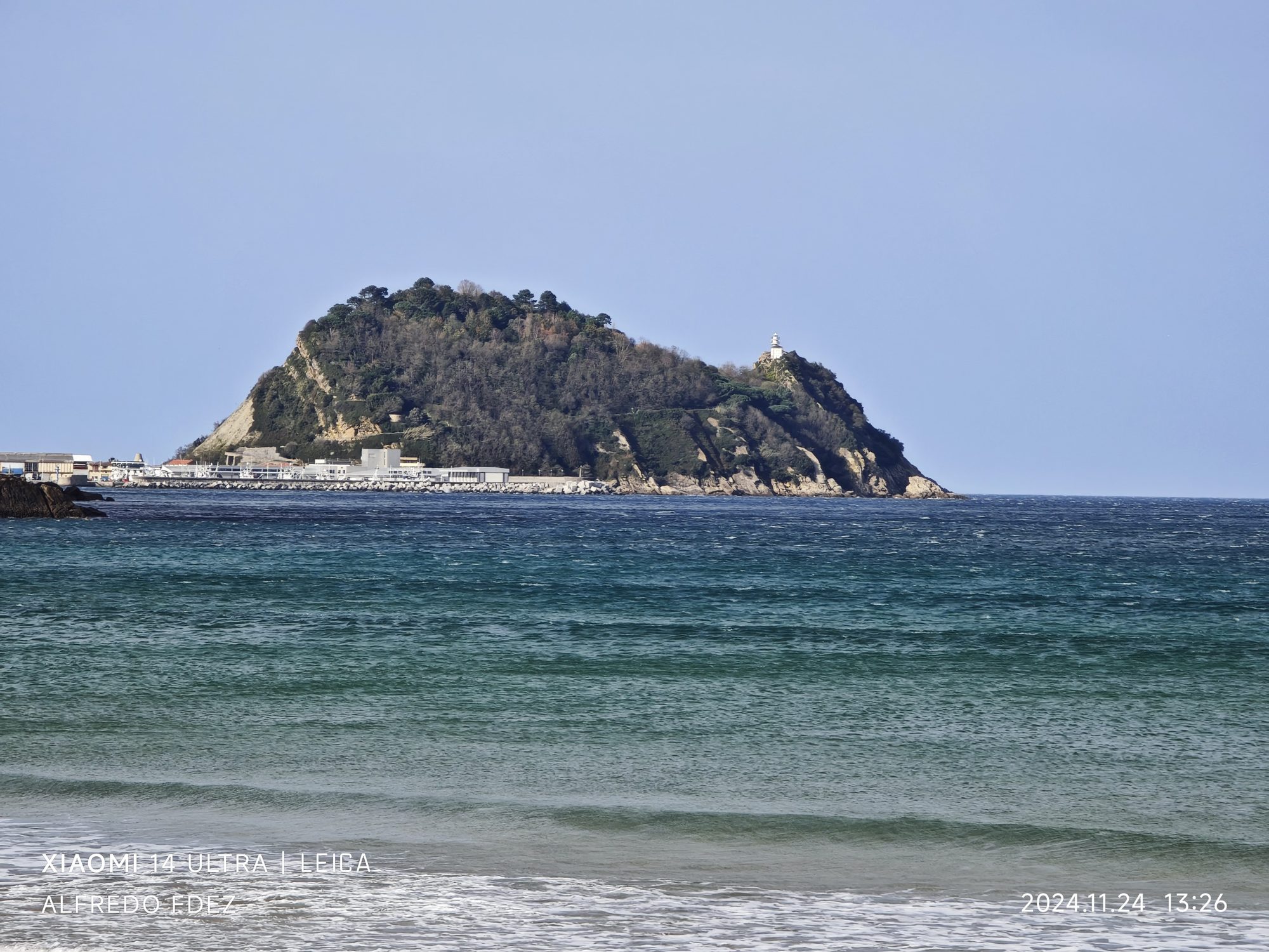 Monte San Antón y faro sobre el mar azul en la costa de Zarauz.