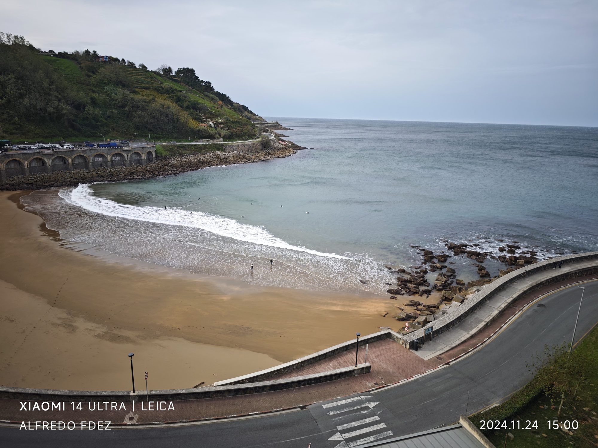 Vista elevada de la playa de arena y costa cantábrica en Guetaria bajo cielo nublado.