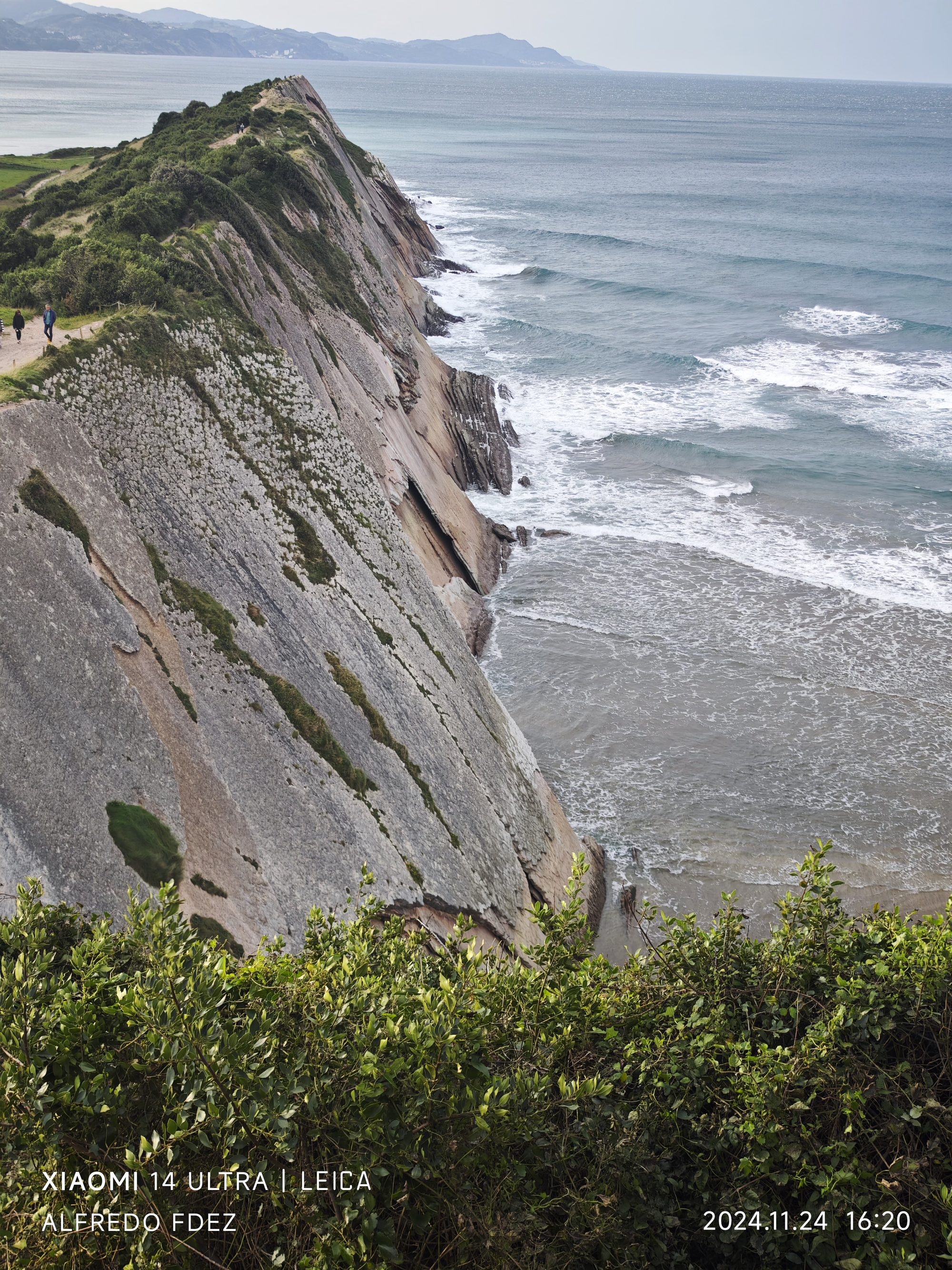 Acantilados del Flysch descendiendo vertiginosamente hacia el mar Cantábrico con oleaje constante.