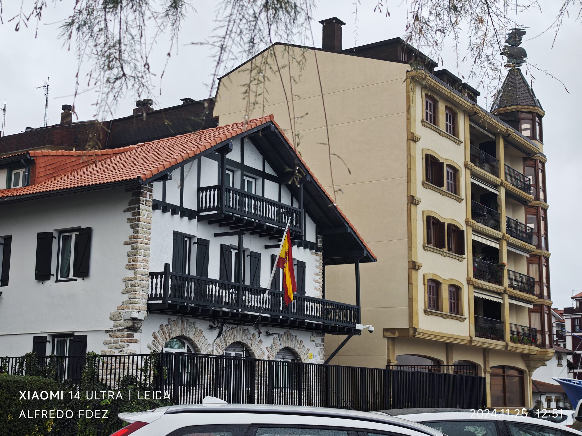 Casa tradicional vasca con balcones de madera y bandera de España en Fuenterrabía.