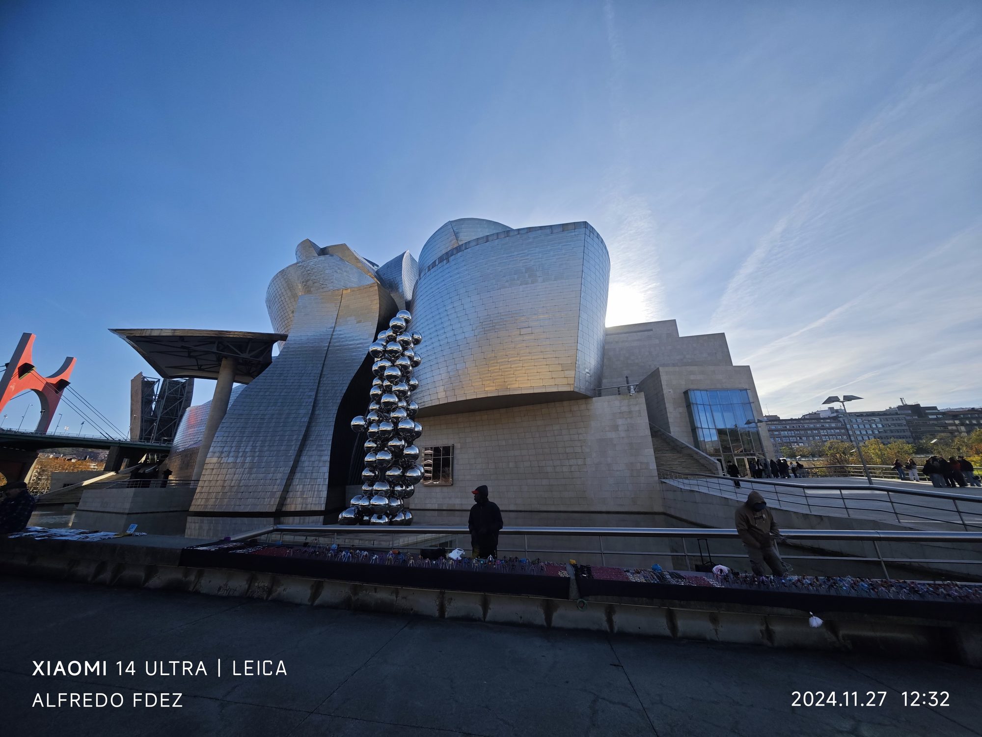 Fachada de titanio del Museo Guggenheim en Bilbao y escultura con esferas metálicas.