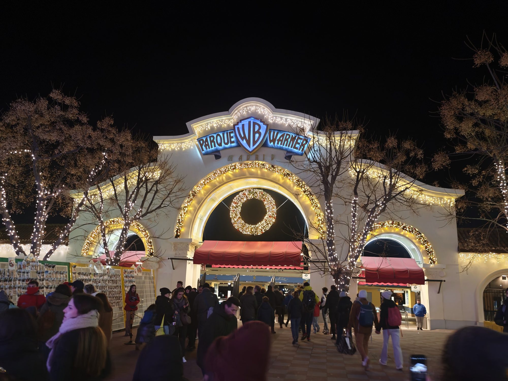 Entrada iluminada del Parque Warner Madrid decorada con luces navideñas por la noche.