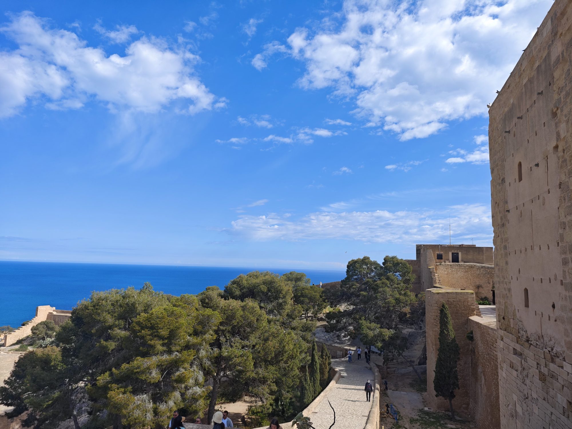 Vista del mar Mediterráneo y vegetación desde las murallas de piedra en Alicante.