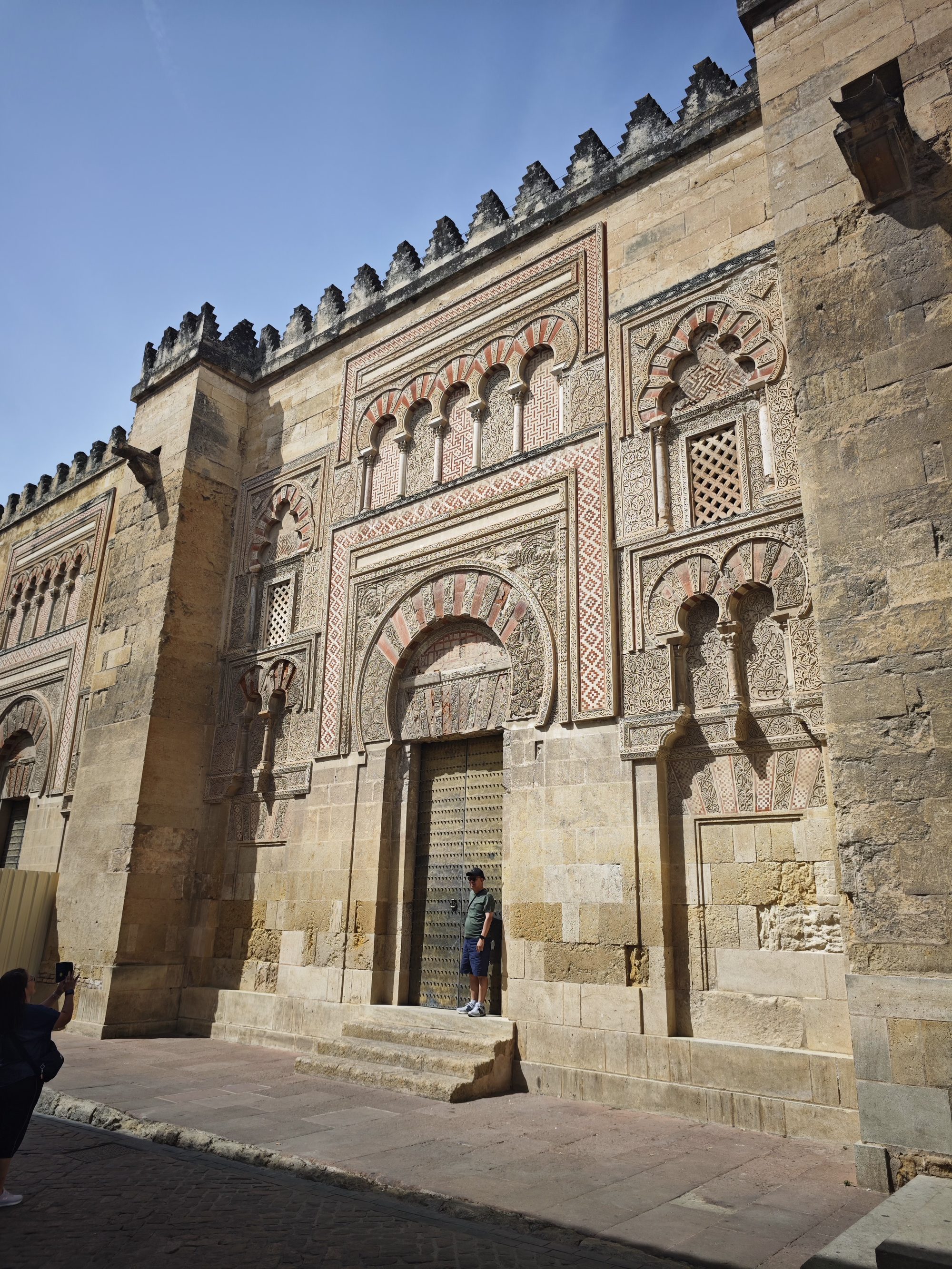 Fachada de piedra esculpida con arcos de herradura ornamentados en la Mezquita de Córdoba.