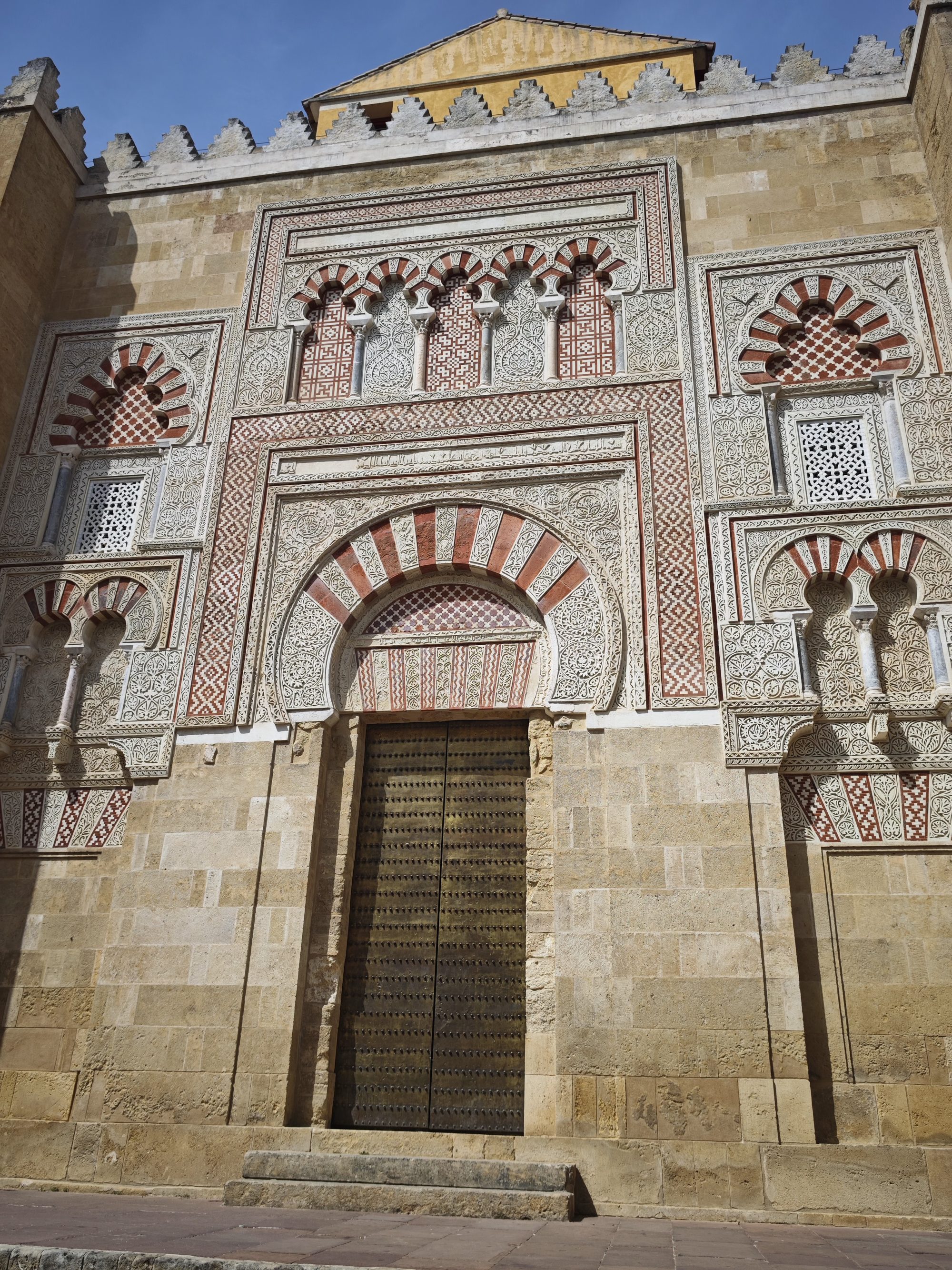 Detalle ornamental de una puerta exterior con arcos califales en la Mezquita de Córdoba.